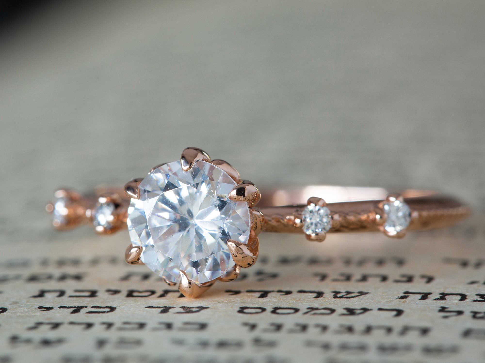 טבעת יהלום וינטג' בזהב 14 קראט אדום על רקע של ספר