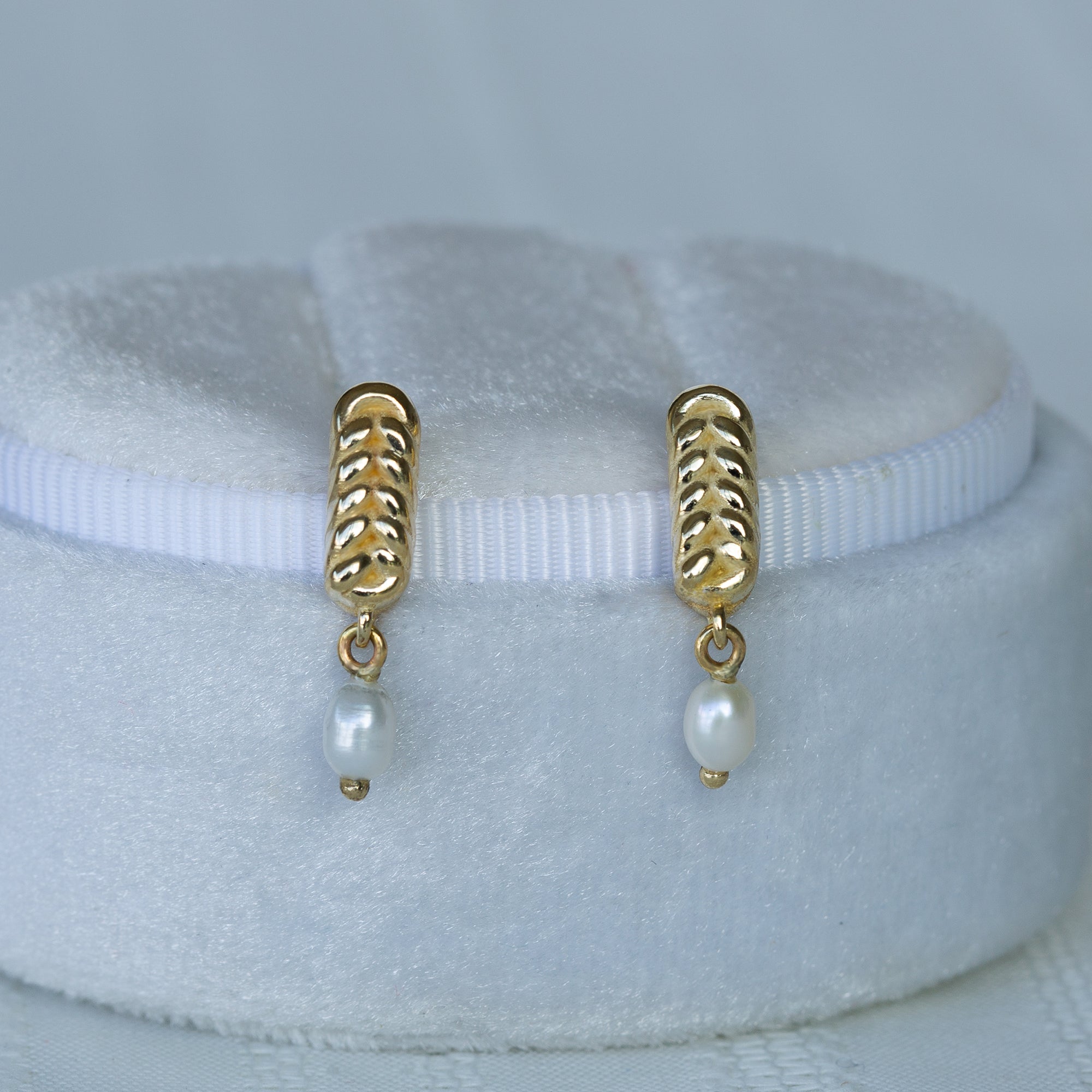 עגיל זהב עם פנינה צמוד לקופסת תכשיטים