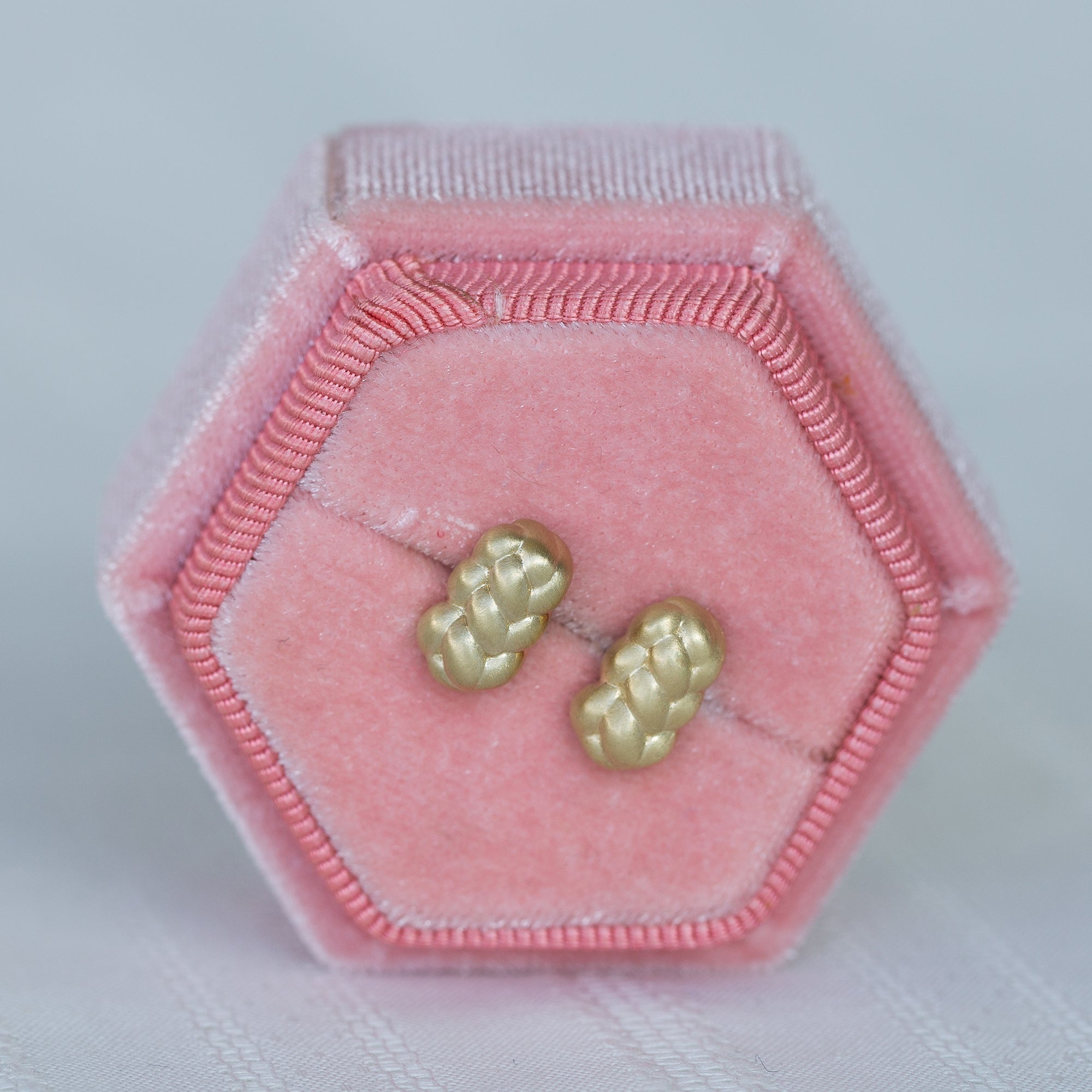 עגילי זהב צהוב צמודים בתוך קופסת תכשיטים ורודה מקטיפה