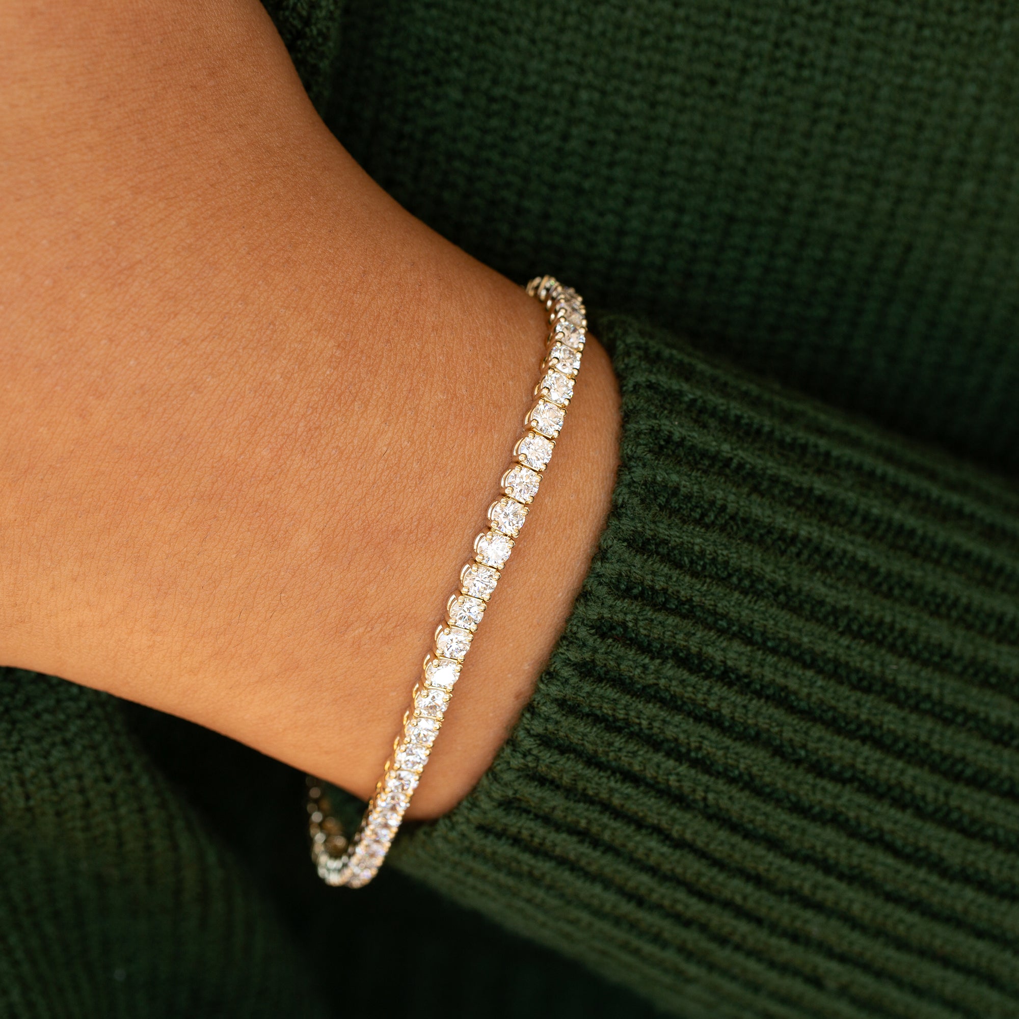 אישה עונדת צמיד טניס משובץ יהלומים לבנים