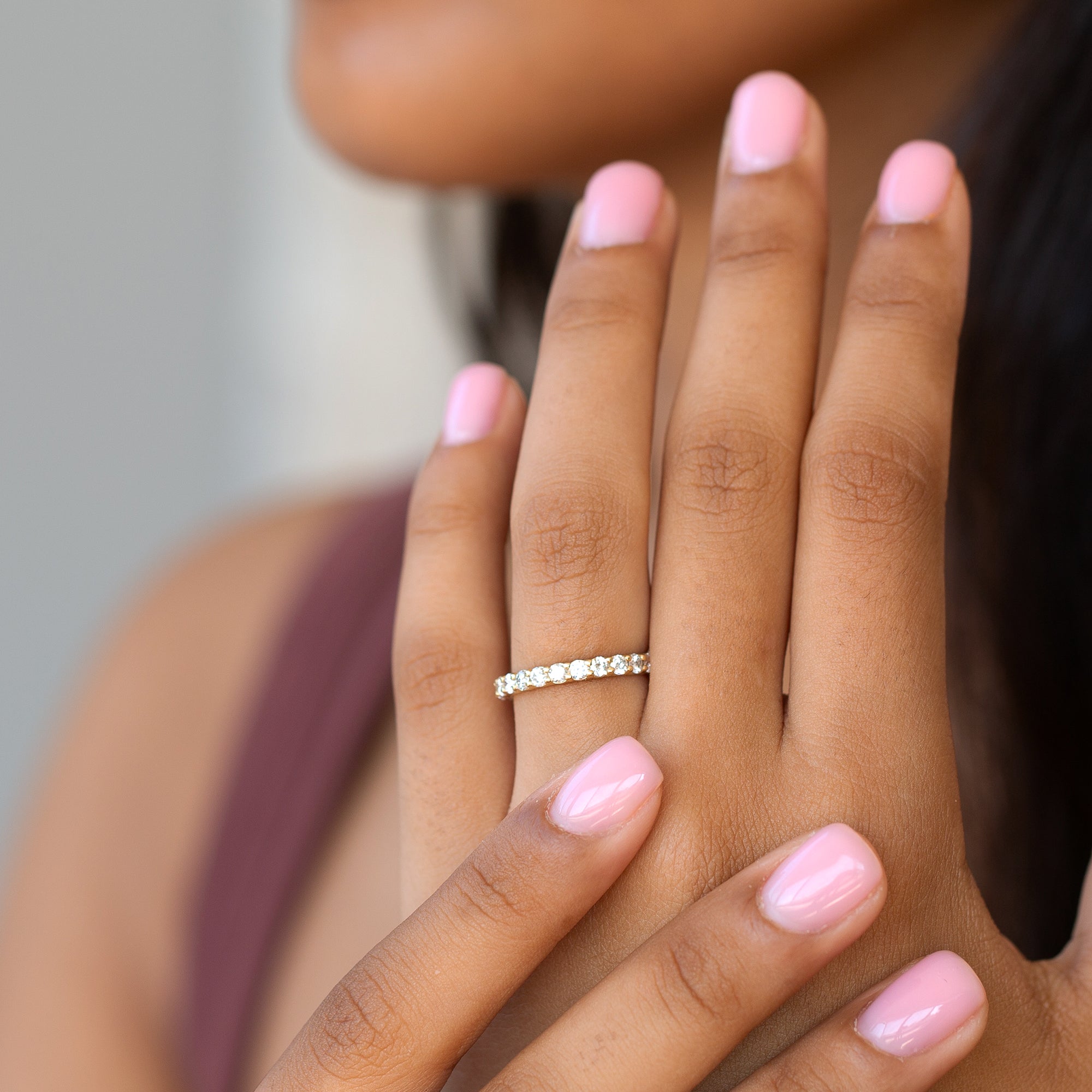 תקריב של יד של אישה עונדת טבעת איטרניטי יהלומים לבנים