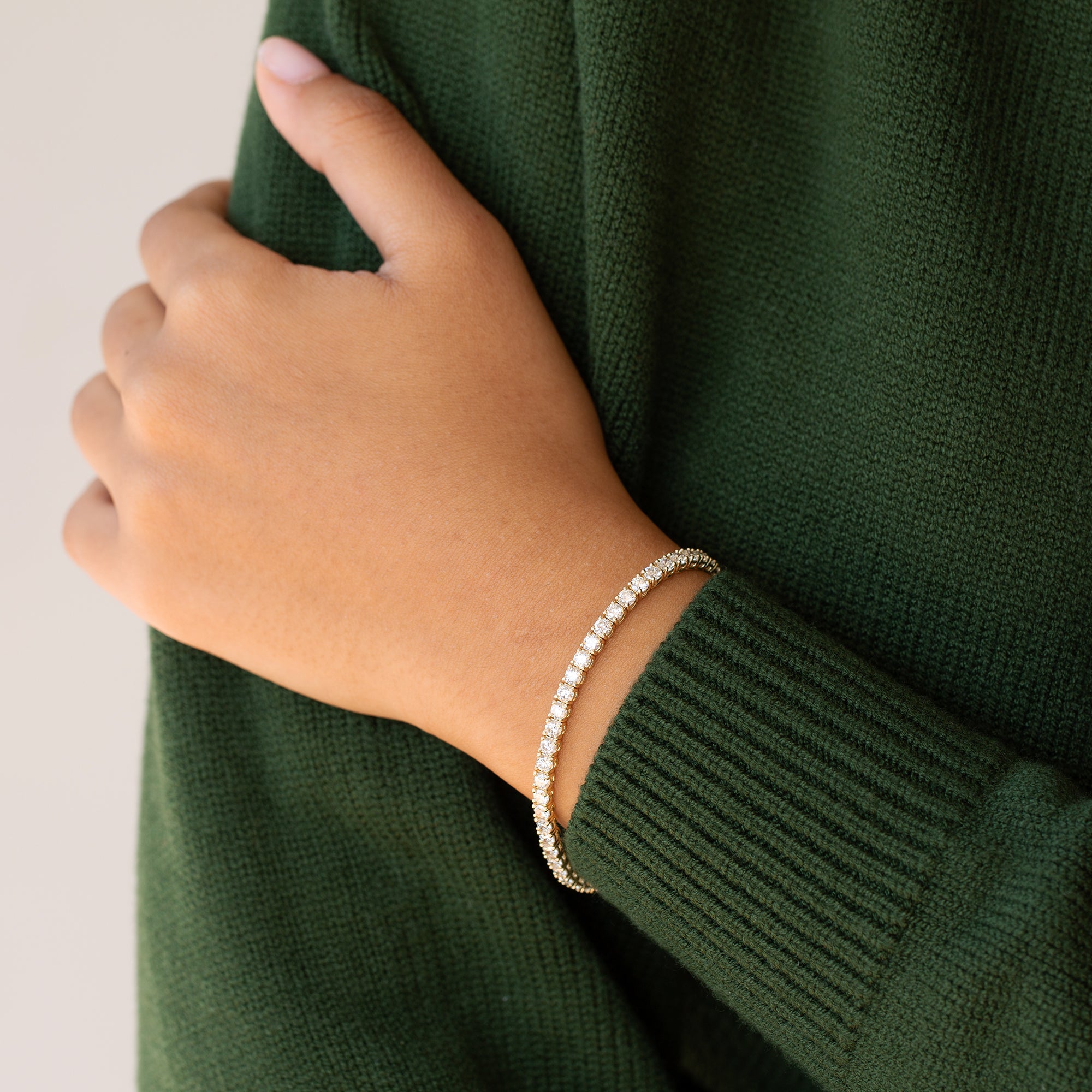 יד של אישה עונדת צמיד טניס קלאסימשובץ יהלומים טבעיים לבנים