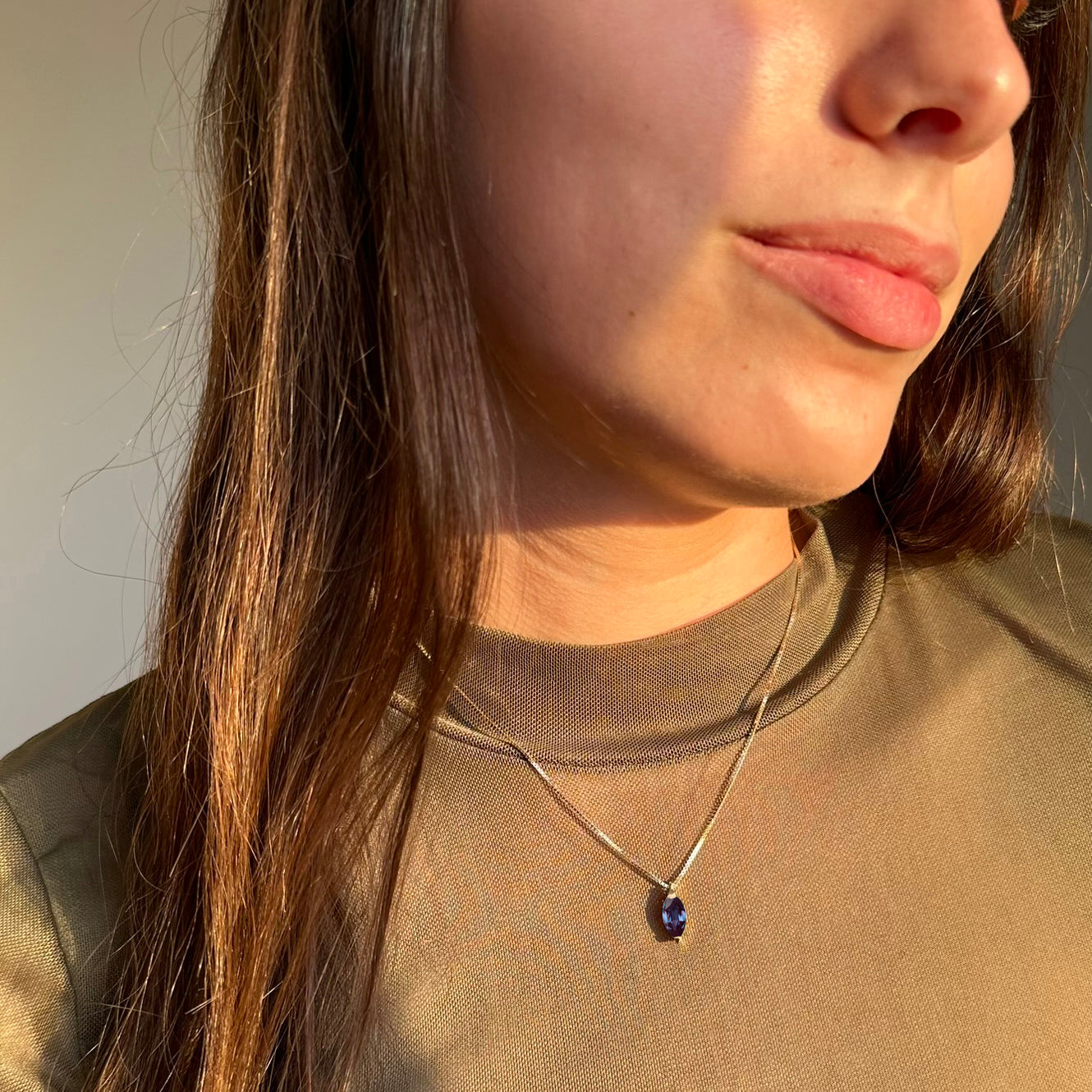 תקריב של אישה שעונדת שרשרת אלכסנדריט מיוחדת