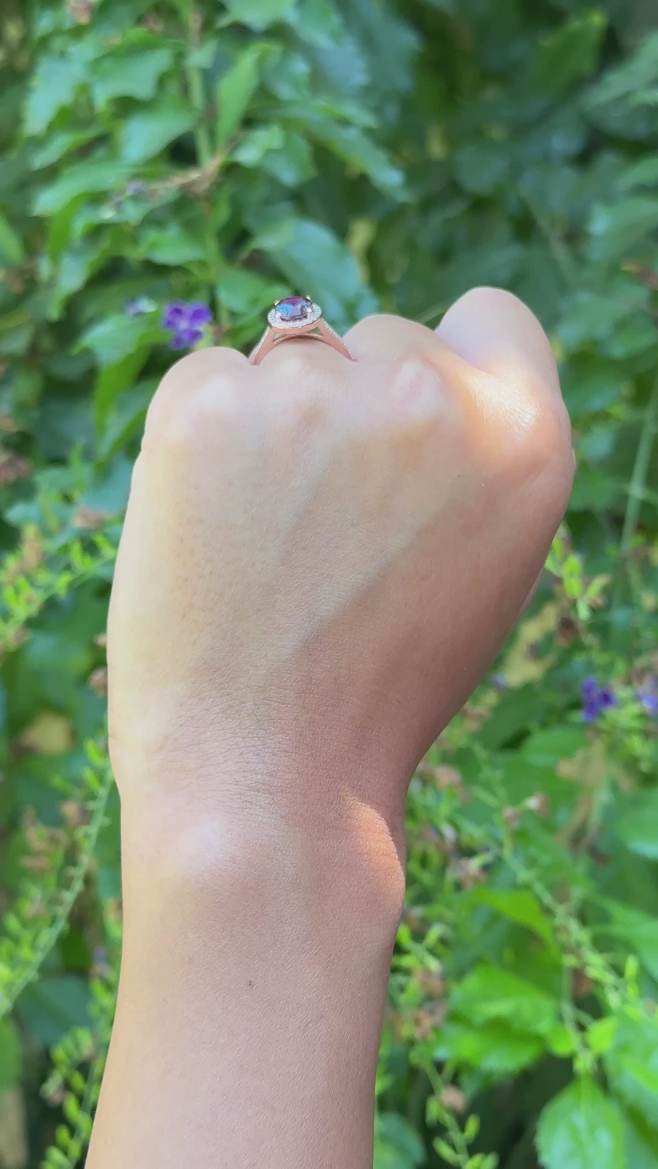 יד של אישה שעונדת טבעת משובצת אבןחן כחולה ויהלומים לבנים