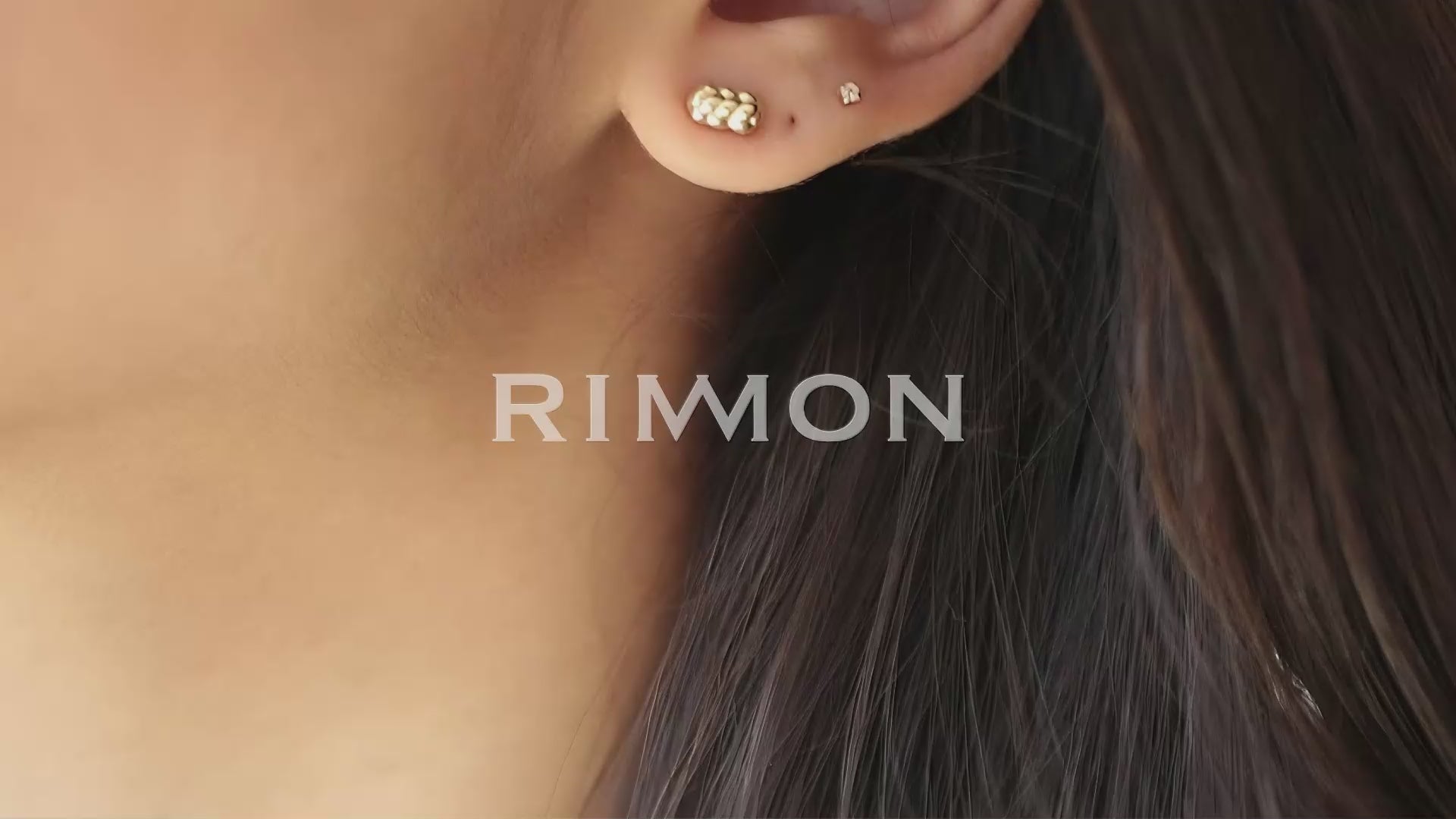 אישה עונדת עגילי זהב צמודים קלועים עדינים בזהב צהוב