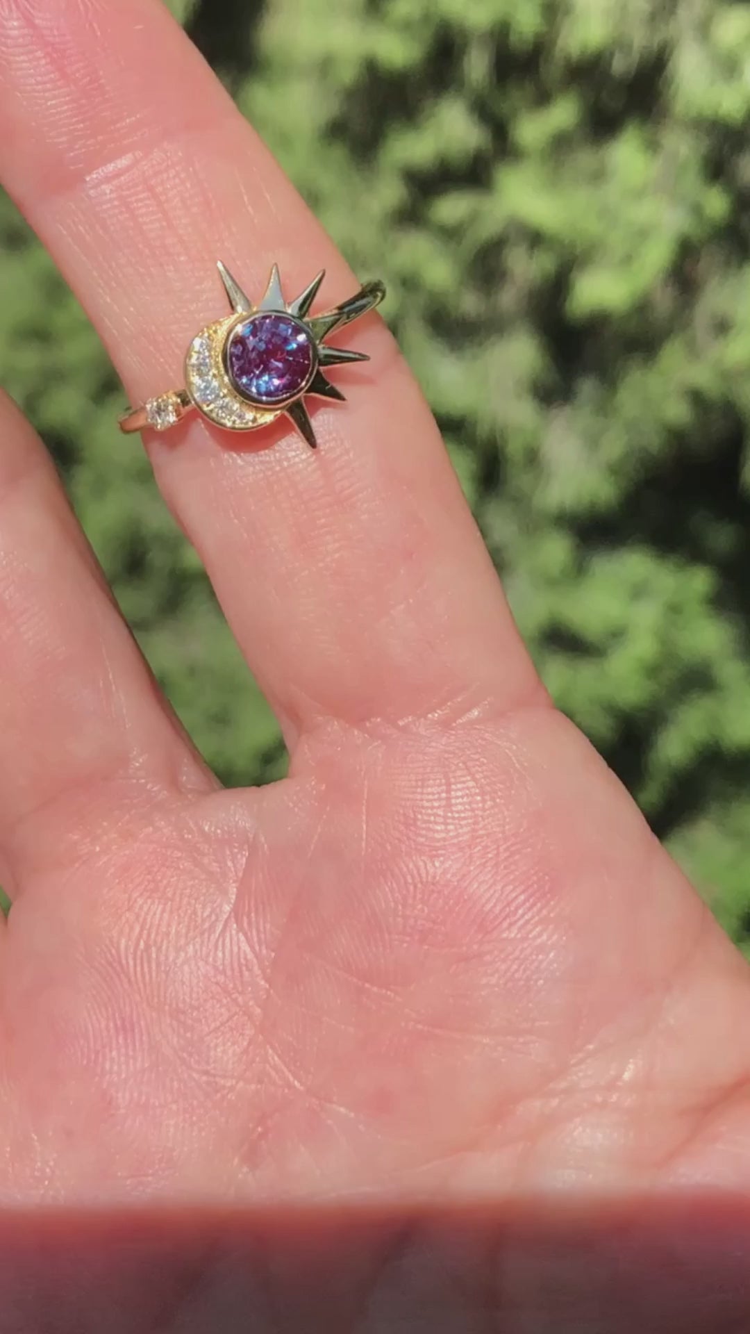 מוצגת אישה עונדת טבעת אלכסנדריט ויהלומים בעיצוב ירח ושמש עשויה זהב צהוב 18 קראט