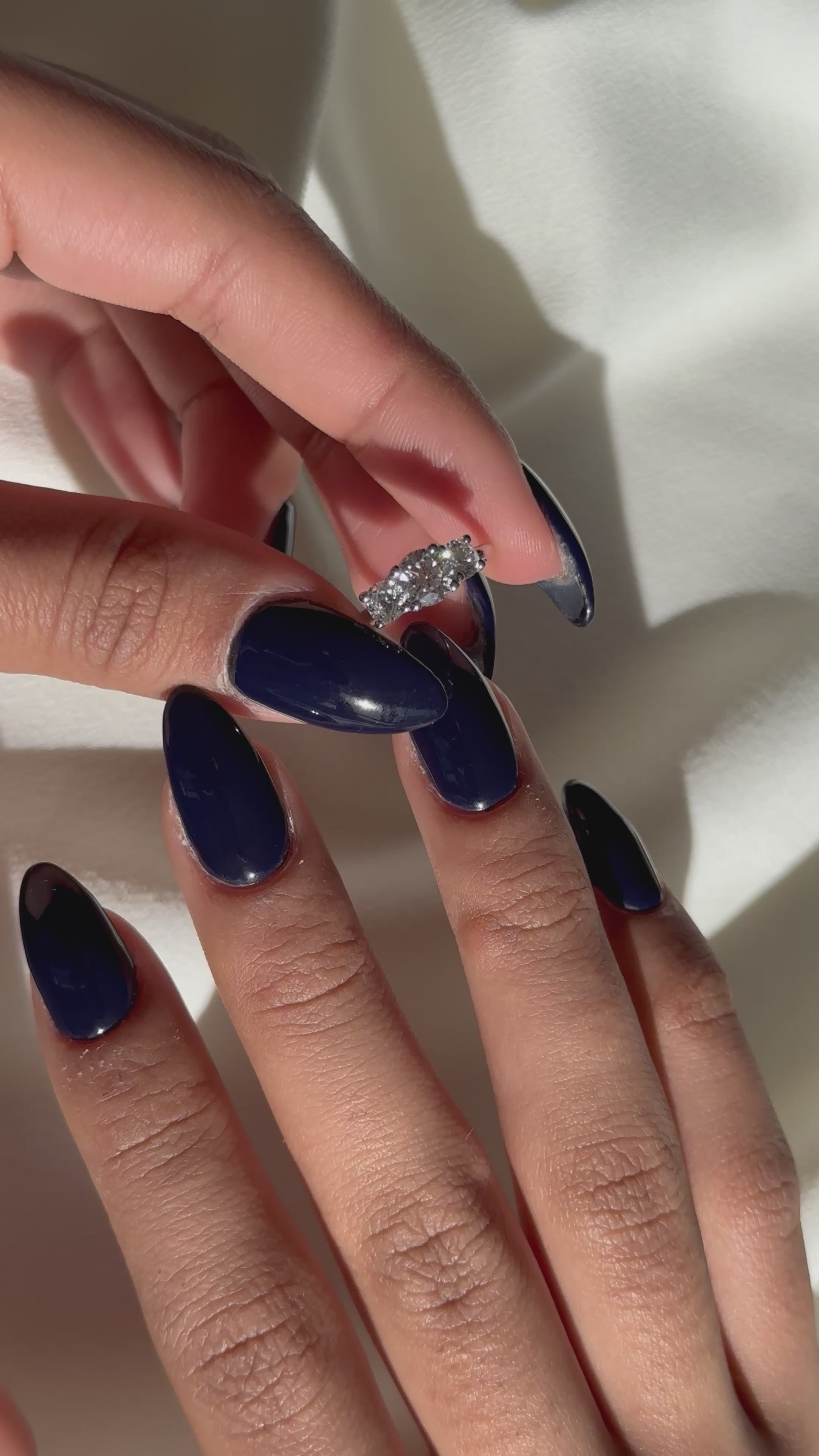 אישה עונדת טבעת אירוסין עדינה משובצת שלושה יהלומי מעבדה