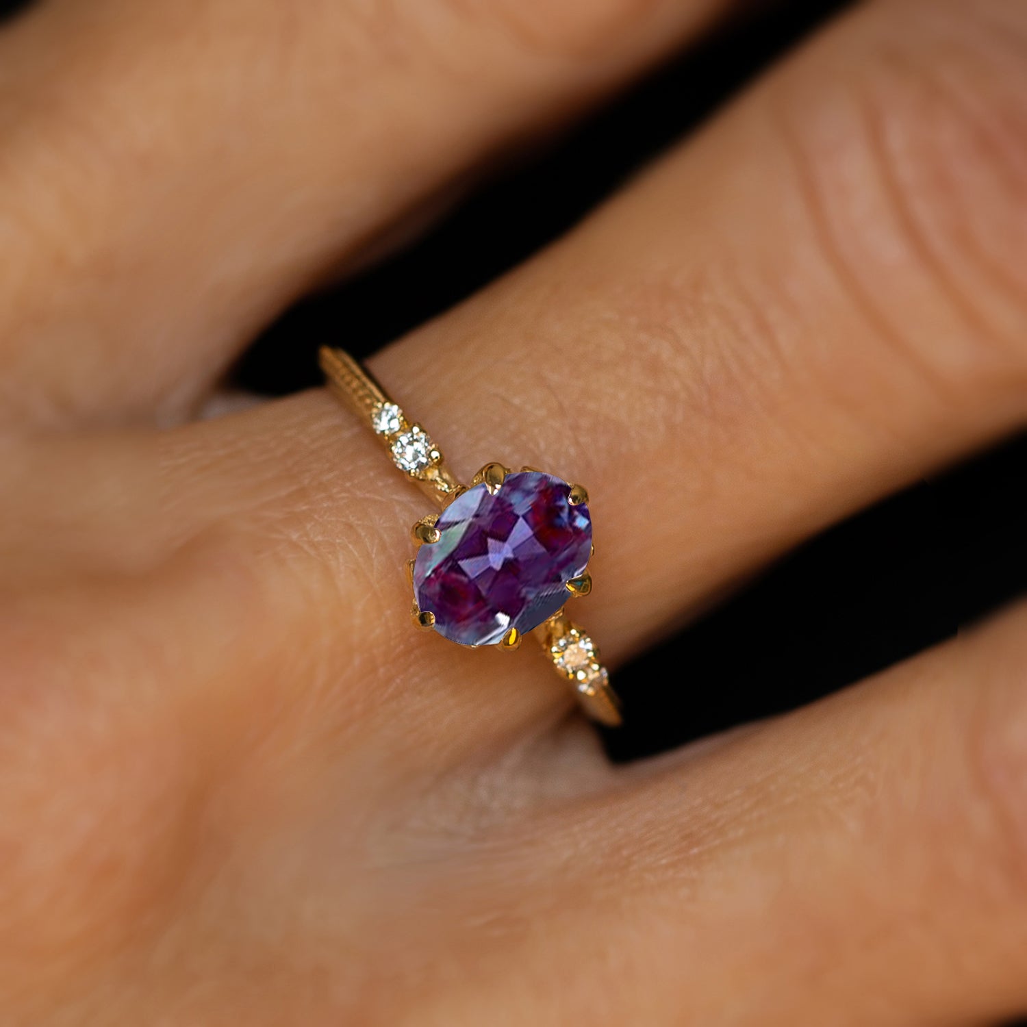 אצבעות של אישה מחזיקות טבעת יהלומים ואבן חן סגולה