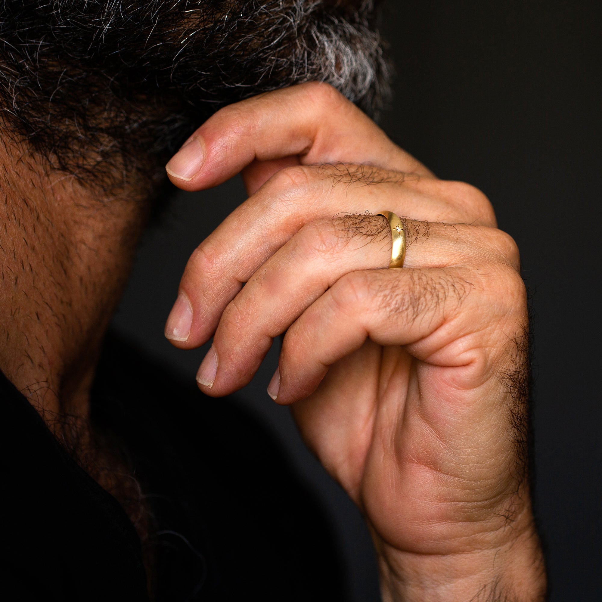 גבר עונד טבעת זהב צהוב 14 קראט משובצת יהלום בעיצוב מיוחד ונקי