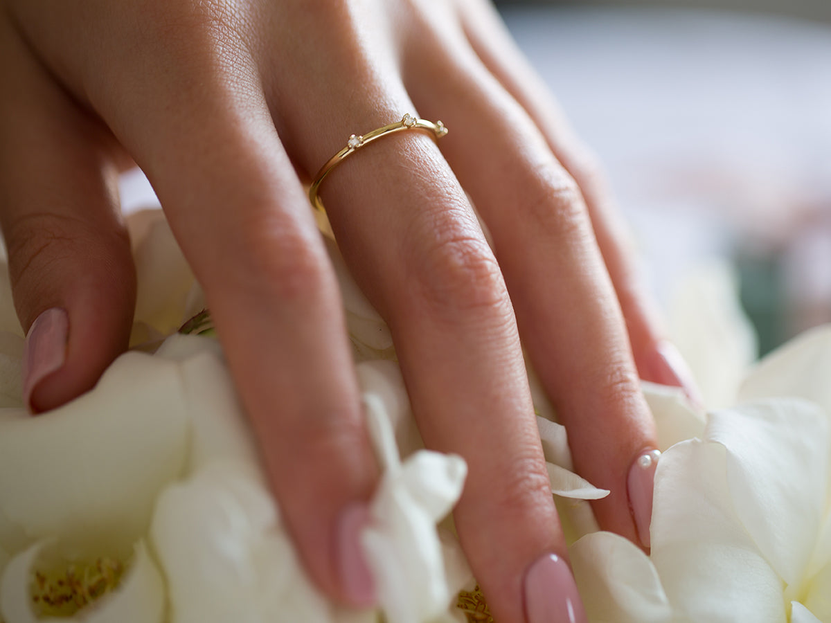 תקריב של יד של אישה שעונדת טבעת יהלומים עדינה