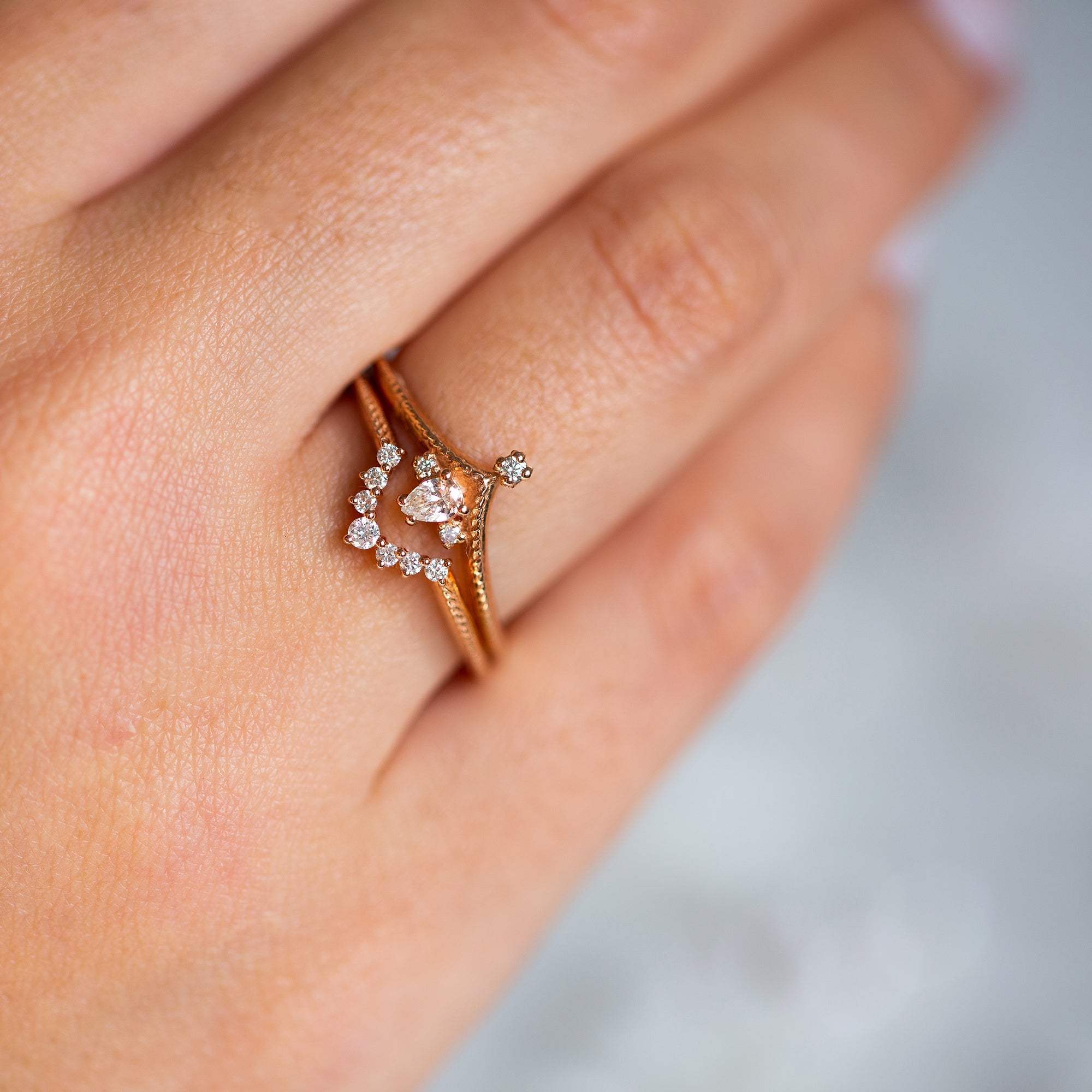 אישה עונדת סט טבעות זהב אדום 14 קראט משובצות יהלומים עדינים בעיצוב מיוחד