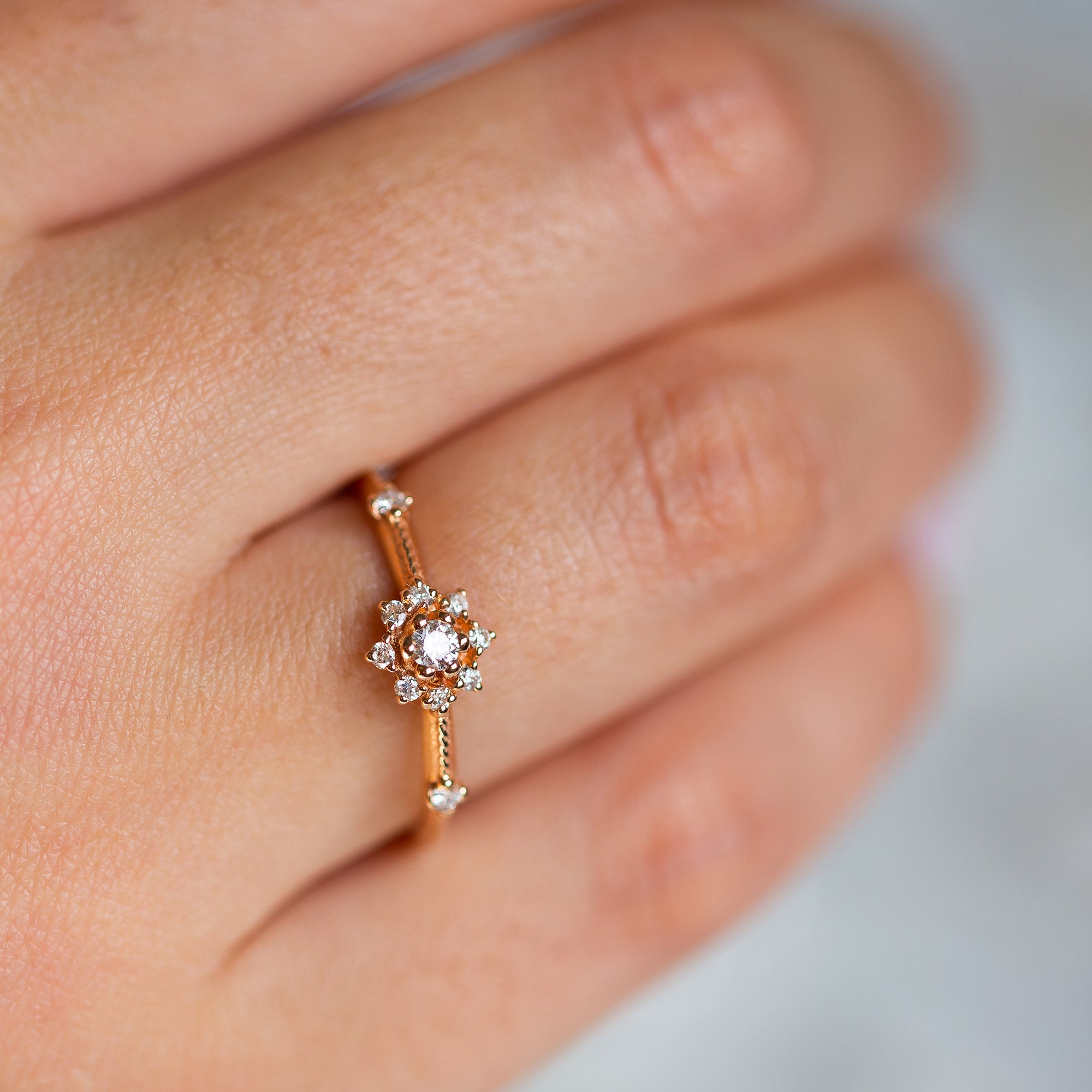 יד של אישה שעונדת טבעת אירוסין עדינה בזהב אדום