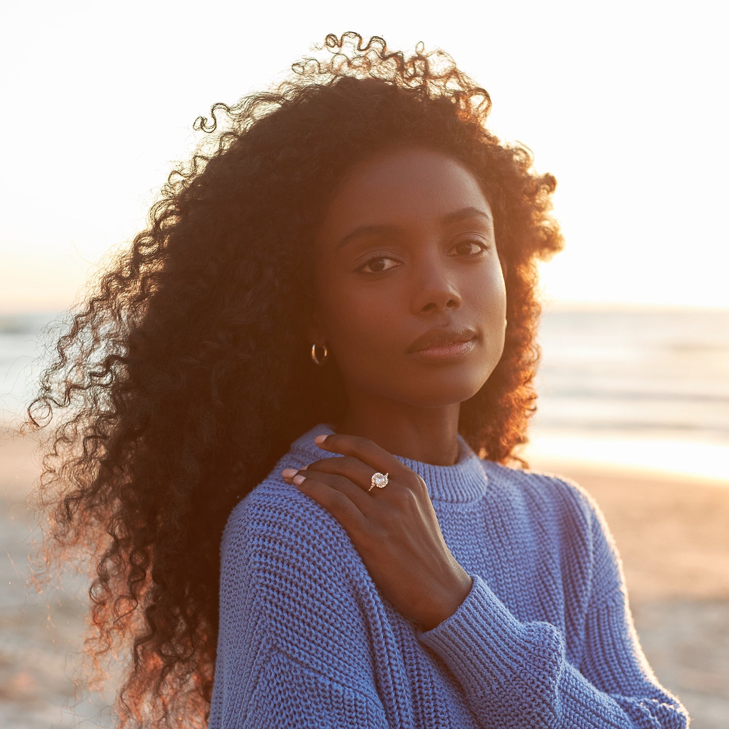 אישה בחוף הים עונדת טבעת זהב 14 קראט משובצת אבן מואסנייט ויהלומים טבעיים