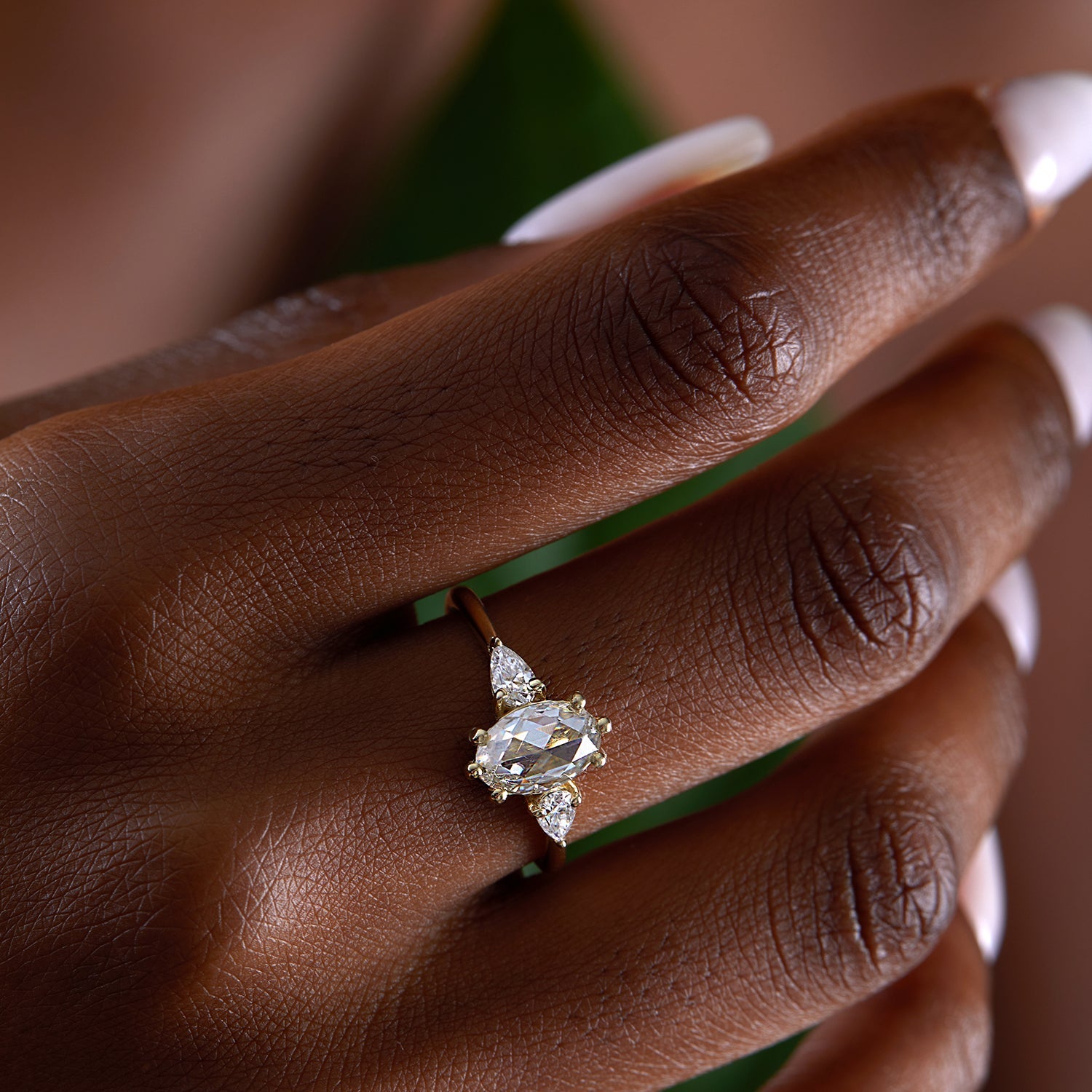 אישה עונדת טבעת אירוסין אובלית משובצת מואסנייט עשויה זהב צהוב 18 קראט בסגנון וינטג'