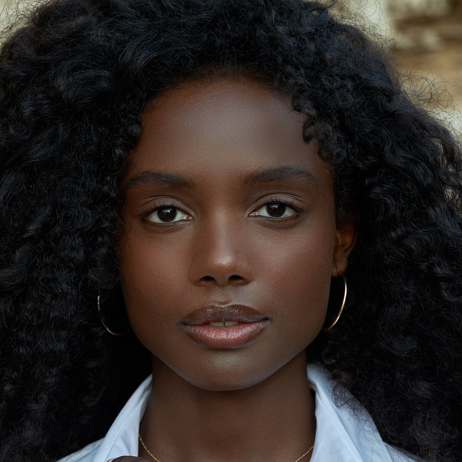 אישה עונדת עגילי חישוק זהב גדולים ועדינים