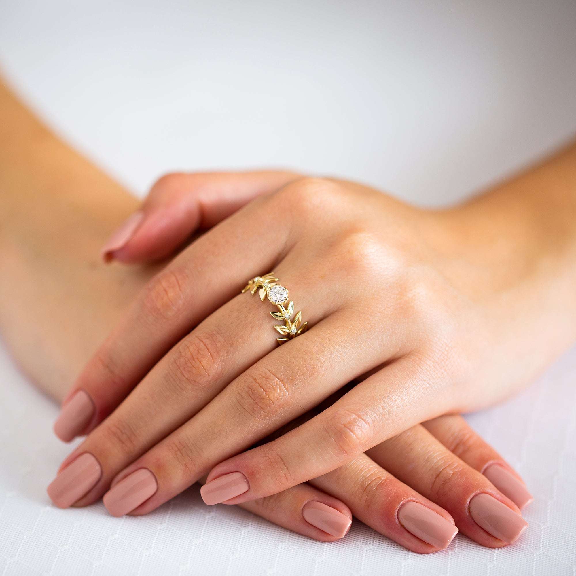 יד של אישה שעונדת טבעת זהב 14 קראט צהוב בעיצוב פרח משובצת יהלומי מעבדה