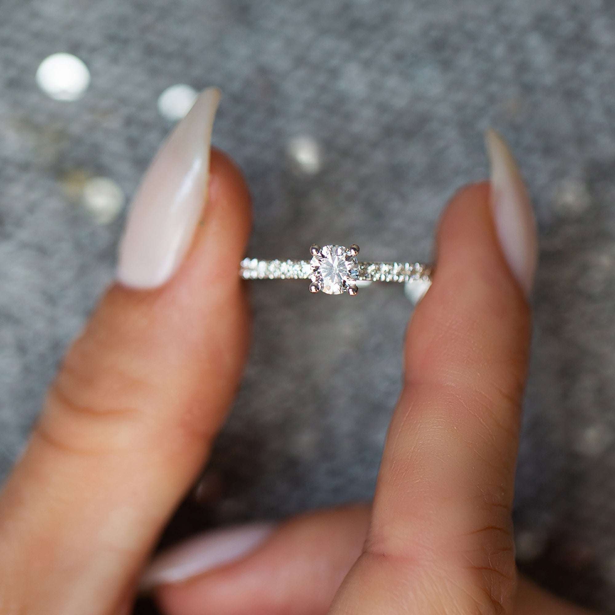 טבעת אירוסין זהב לבן קלאסית משובצת יהלומי מעבדה אחוזה באצבעות של אישה