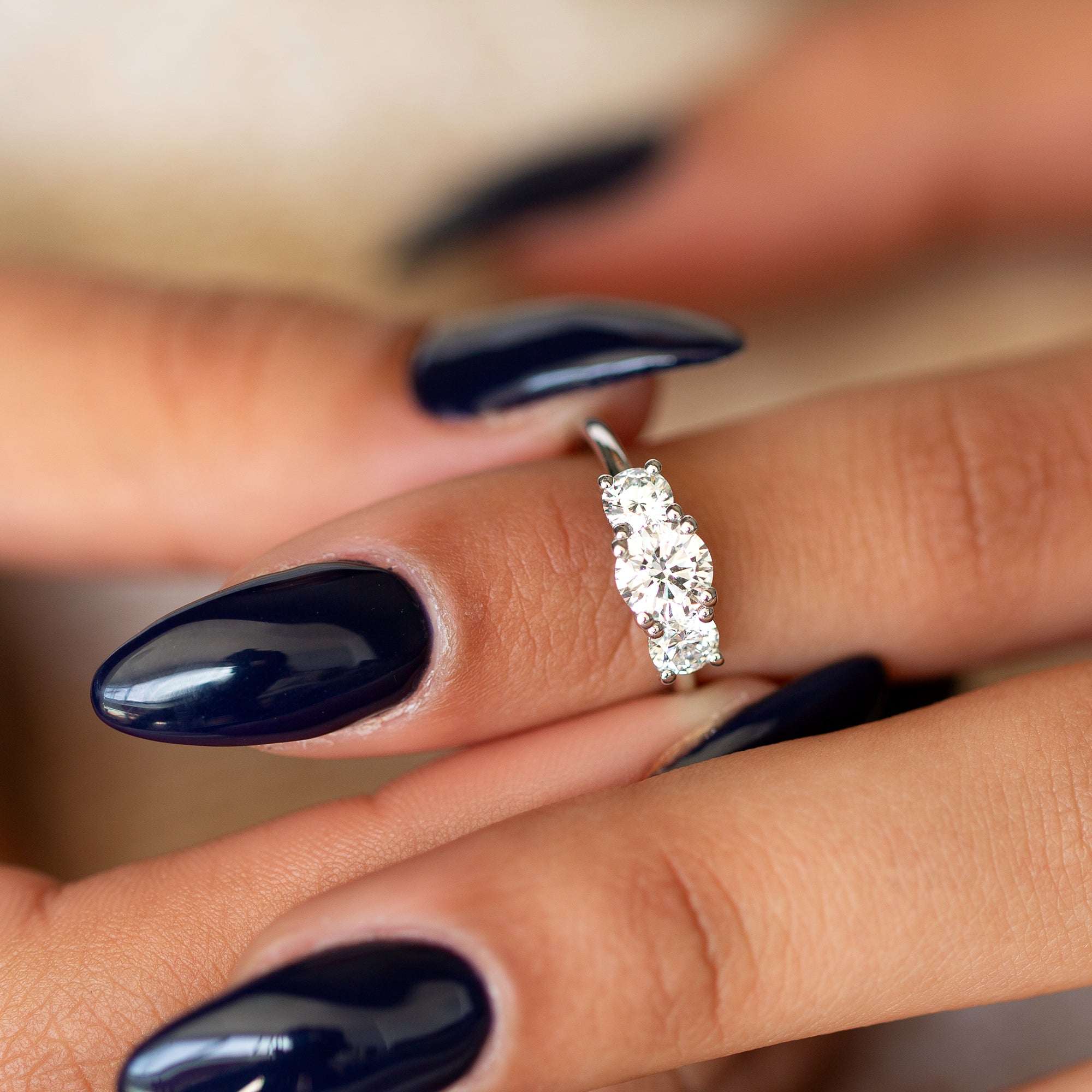 אישה עונדת טבעת זהב לבן 14 קראט משובצת שלושה יהלומי מעבדה לבנים