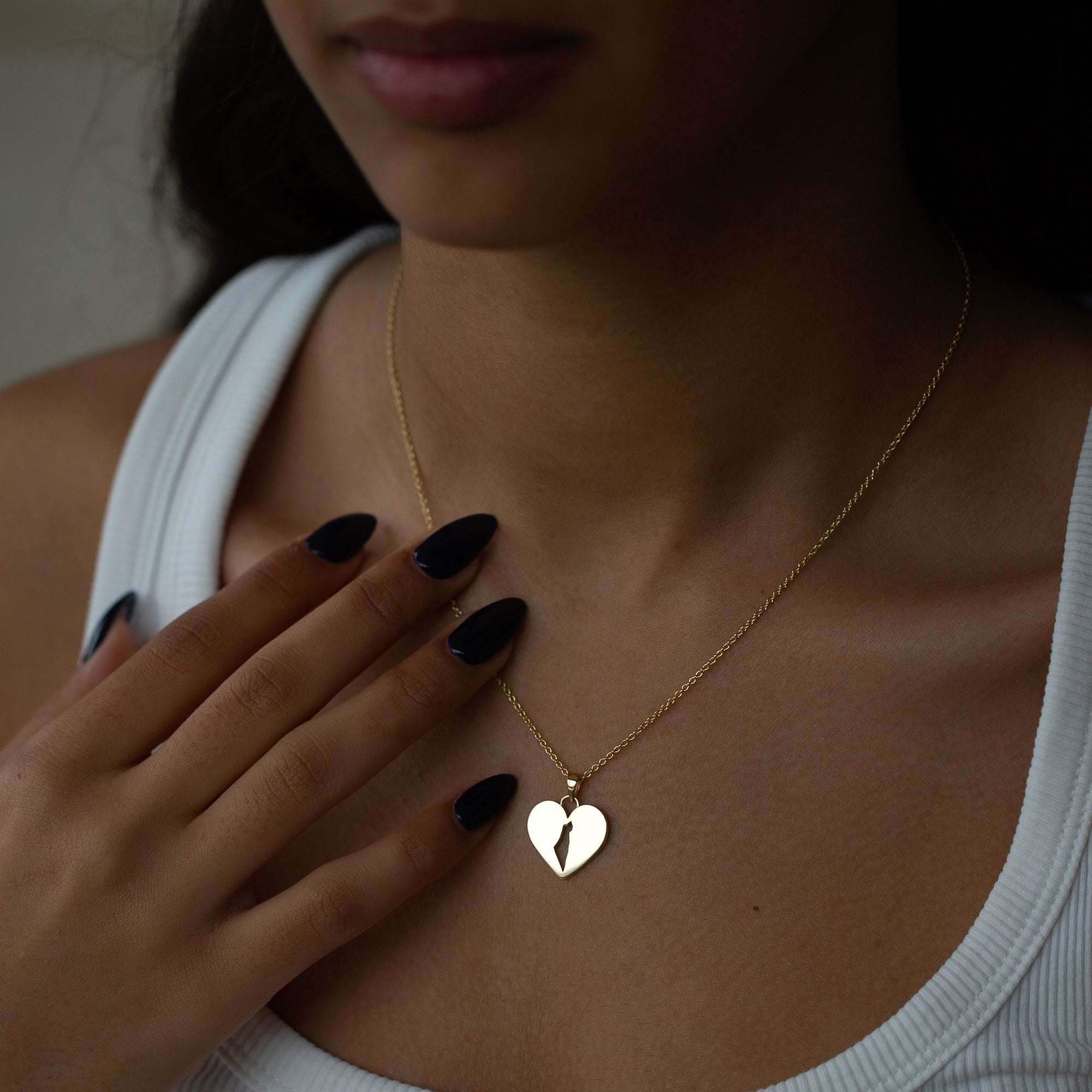 תקריב של אישה שעונדת שרשרת שרשרת מפת ישראל מזהב