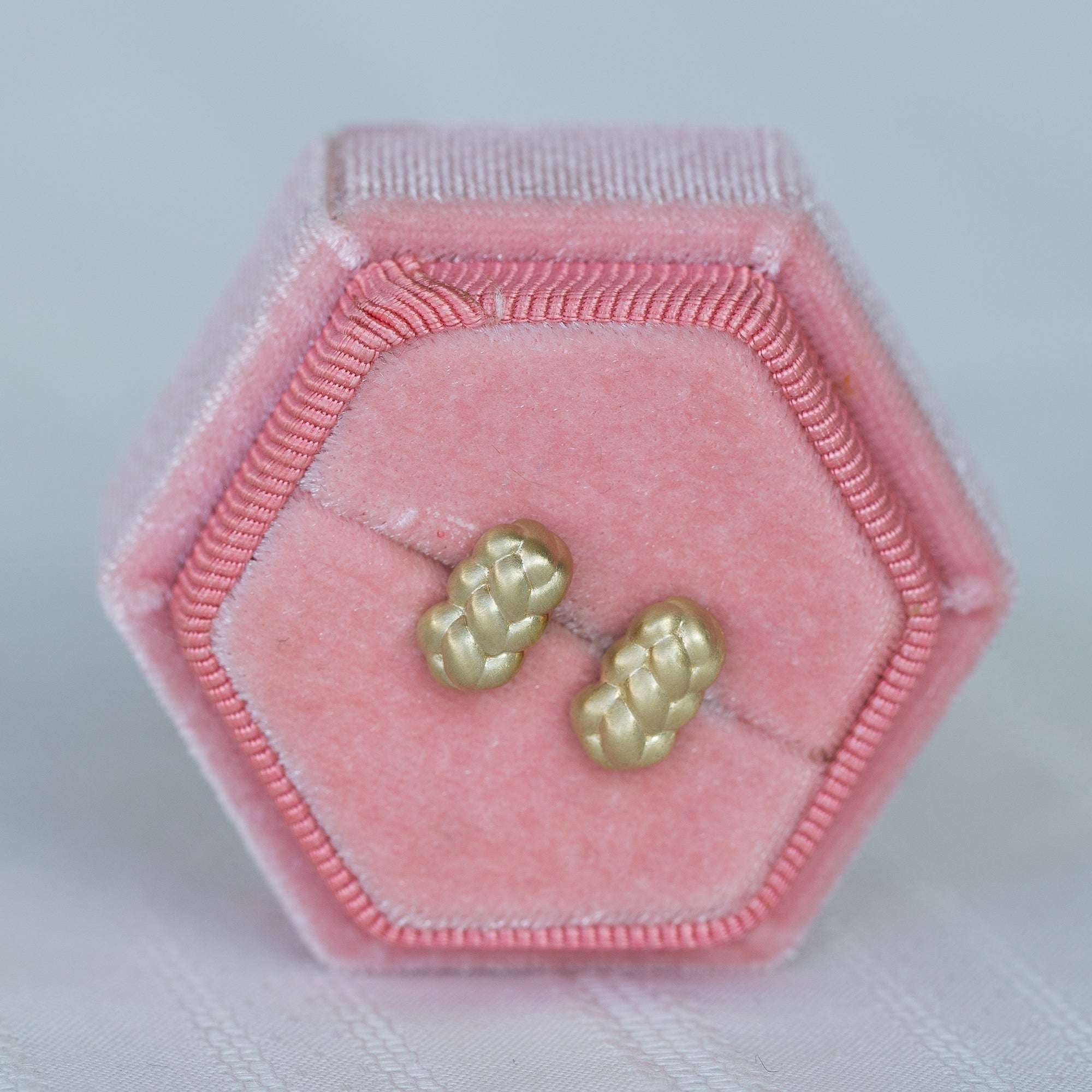 עגילי זהב צהוב צמודים בתוך קופסת תכשיטים ורודה מקטיפה