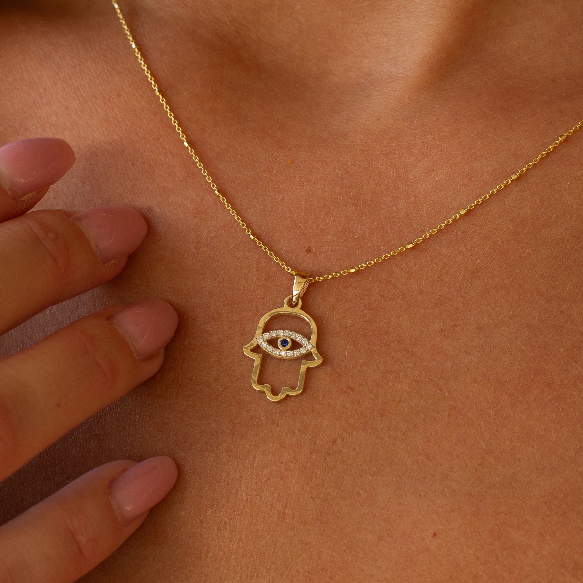 תקריב מאקרו של שיבוץ היהלומים בתליון חמסה על צוואר דוגמנית