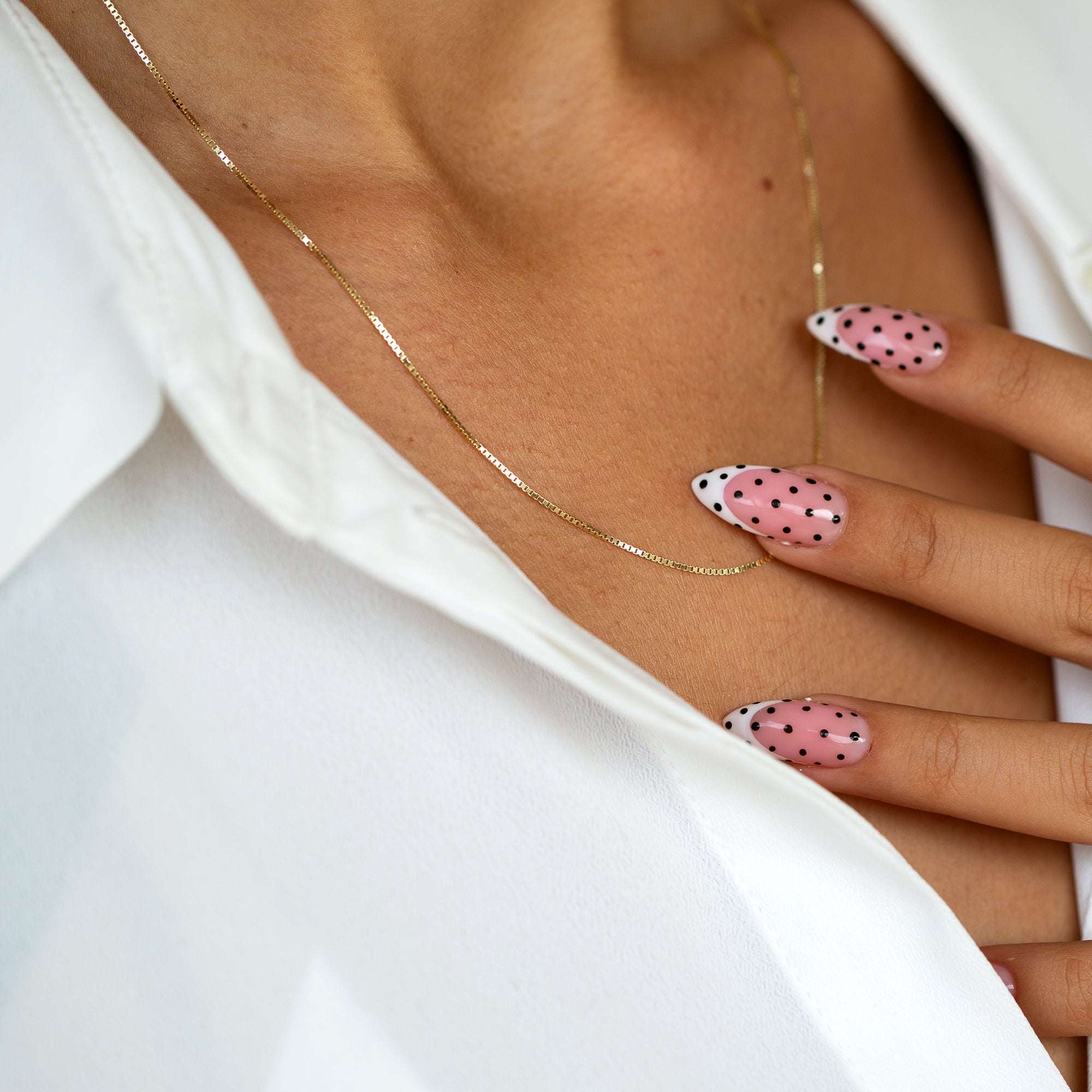 שרשרת זהב דקה בסגנון קלאסי על צוואר אישה להמחשת מראה שכבות אופנתי.