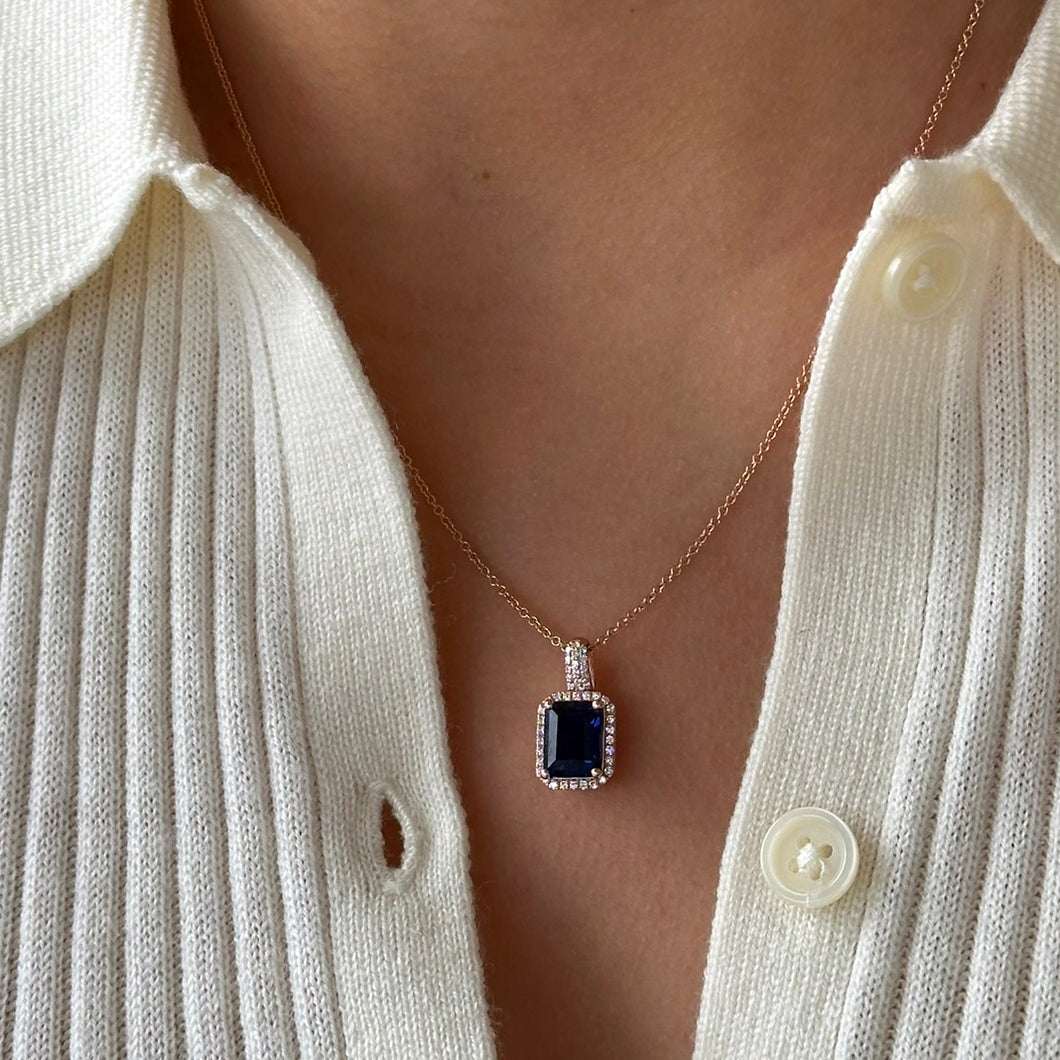 תקריב תליון ספיר כחולה ויהלומים על רקע בהיר, הדגשת שיבוץ האבנים