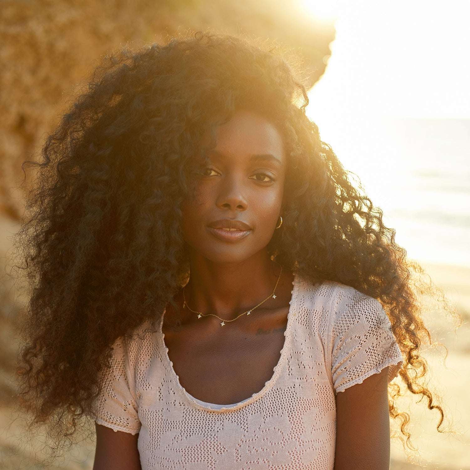 אישה עונדת שרשרת צ'וקר מזהב עם תליוני כוכבים