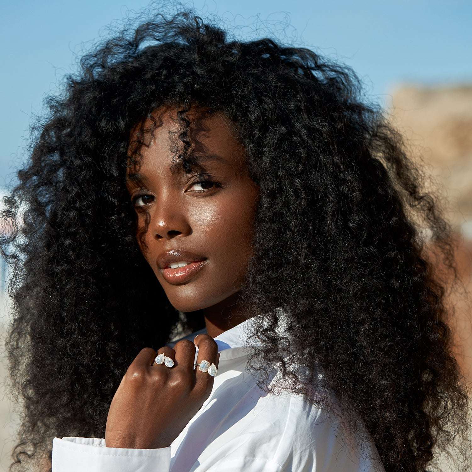 אישה עונדת שתי טבעות יהלומים מיוחדות משובצות יהלום טיפה