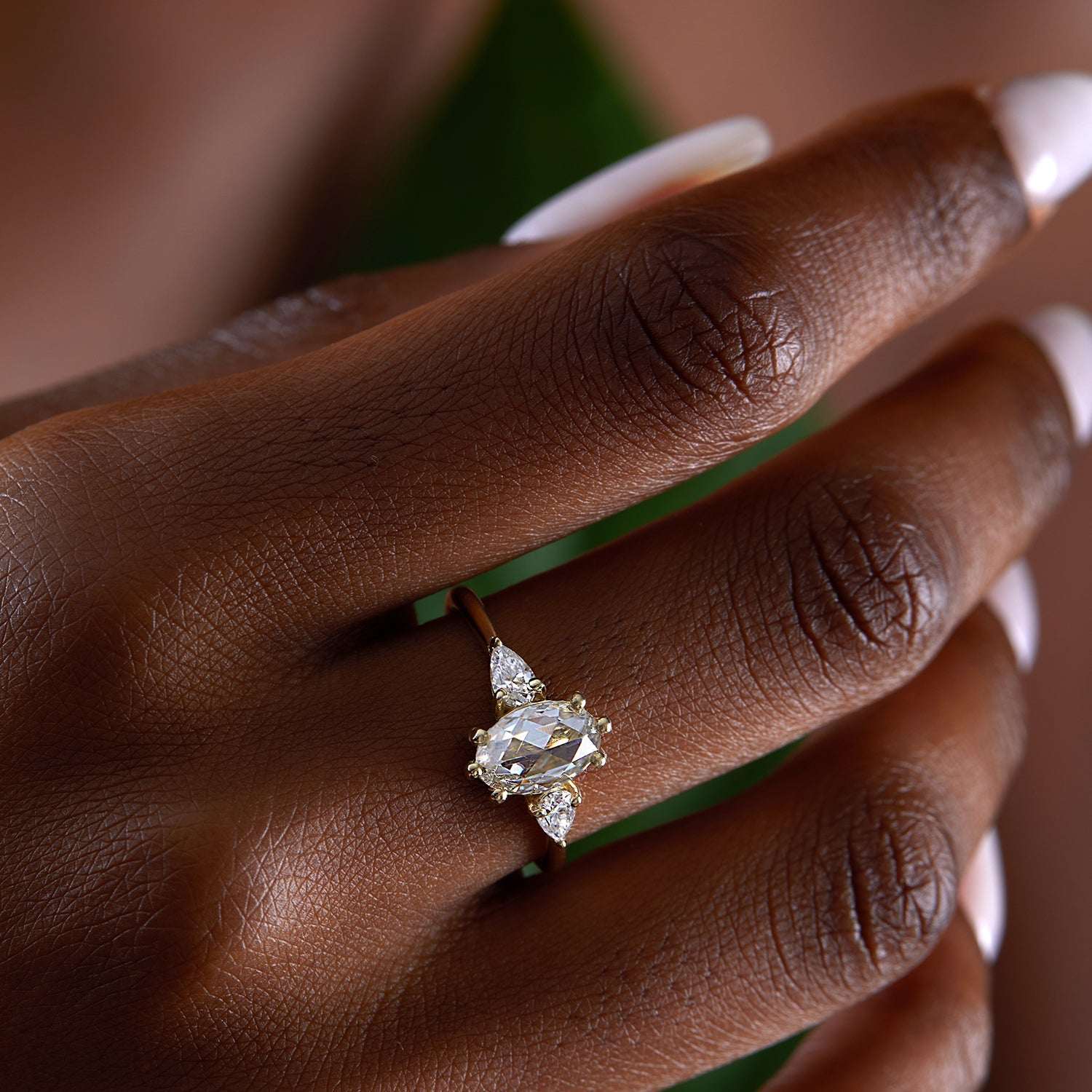 אישה עונדת טבעת אירוסין אובלית משובצת מואסנייט עשויה זהב צהוב 18 קראט בסגנון וינטג' 