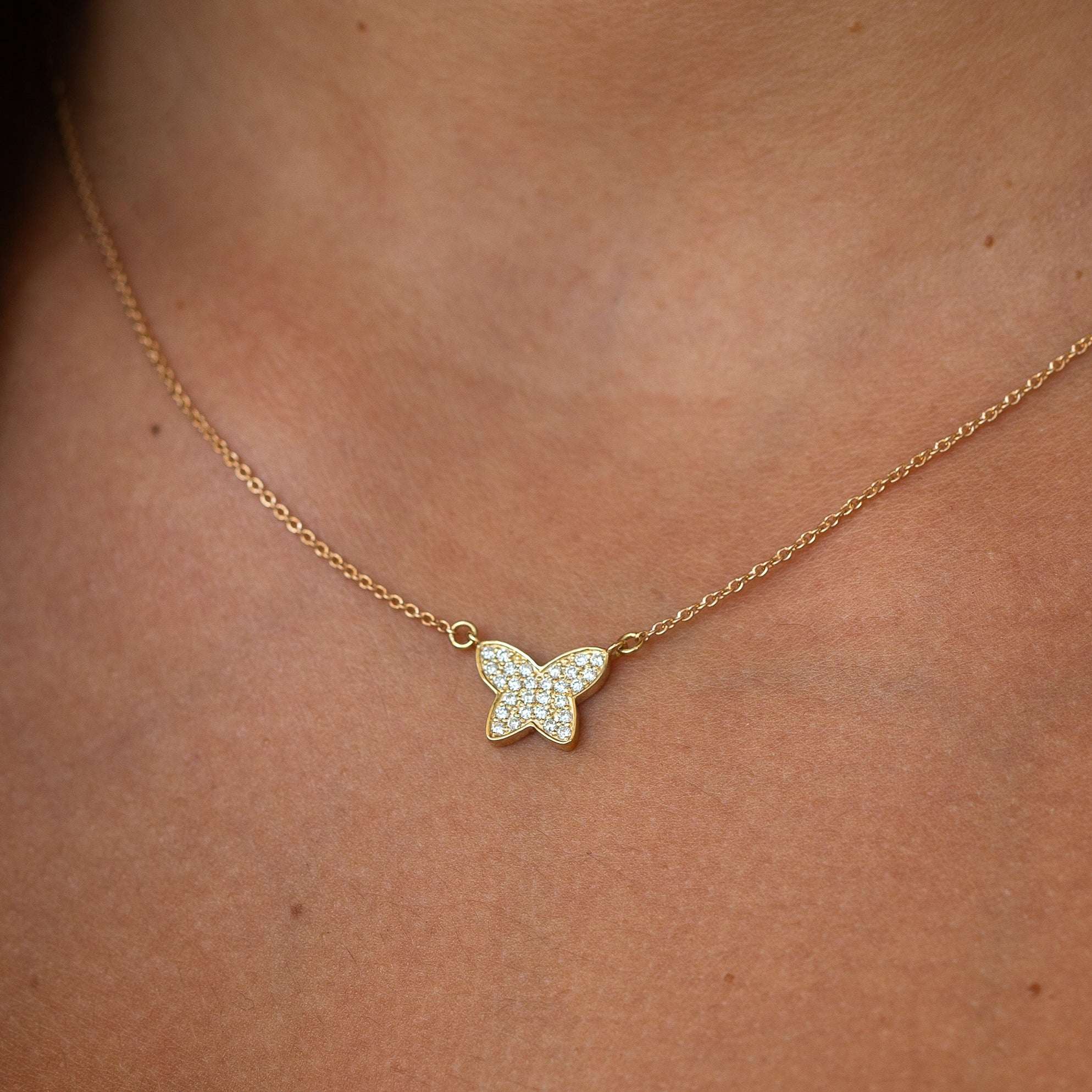 תקריב של שרשרת פרפר על קו הצוואר של דוגמנית