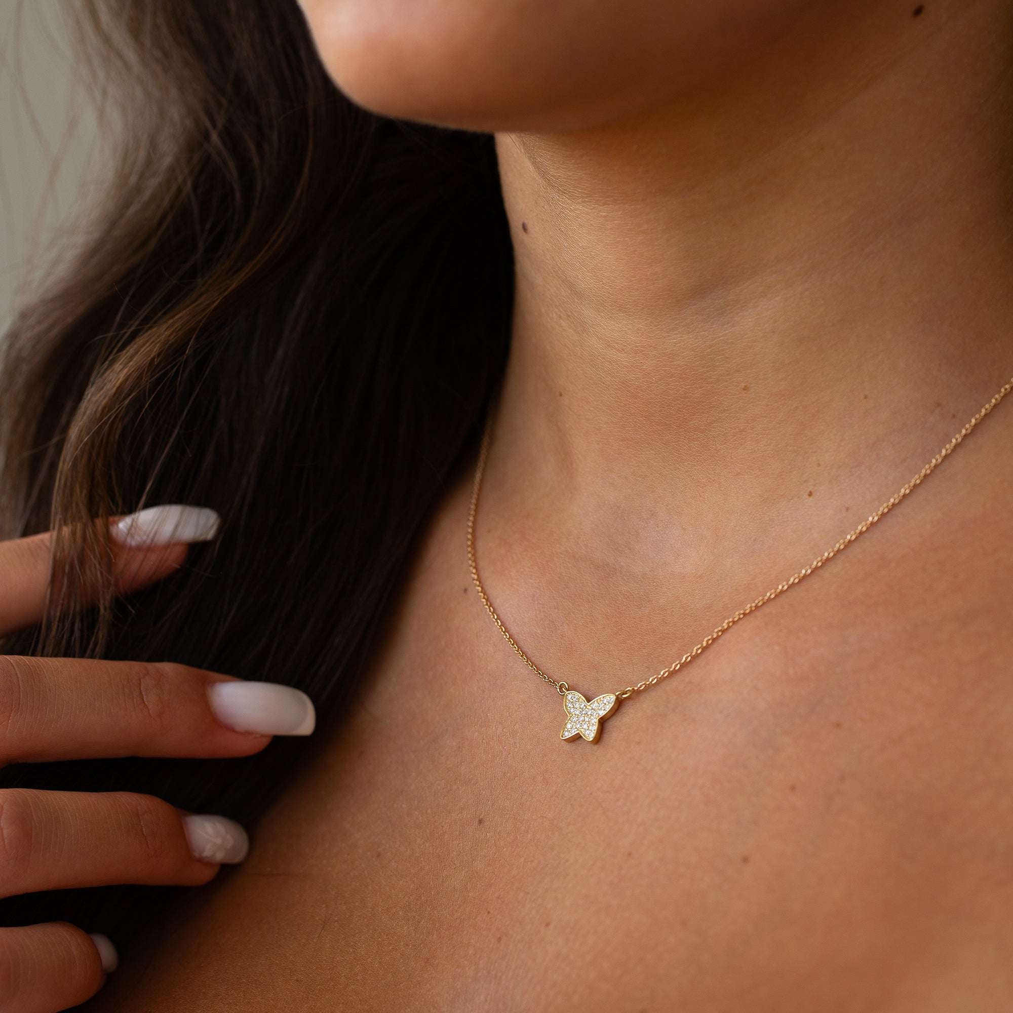 תליון פרפר עדין על צוואר של אישה
