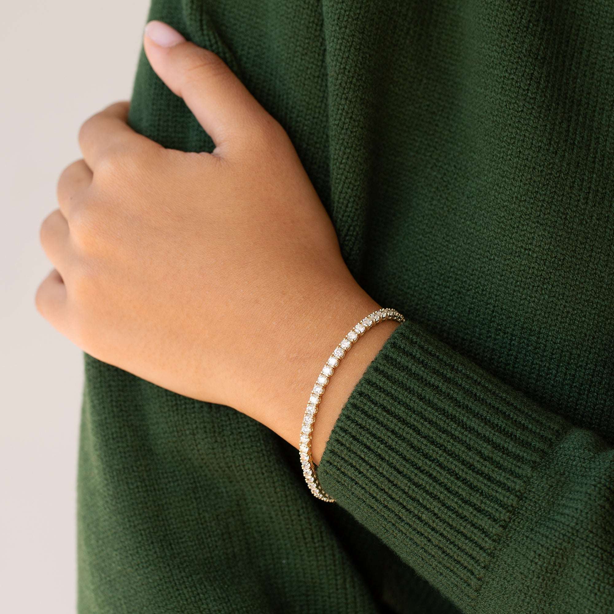 יד של אישה עונדת צמיד טניס קלאסימשובץ יהלומים טבעיים לבנים