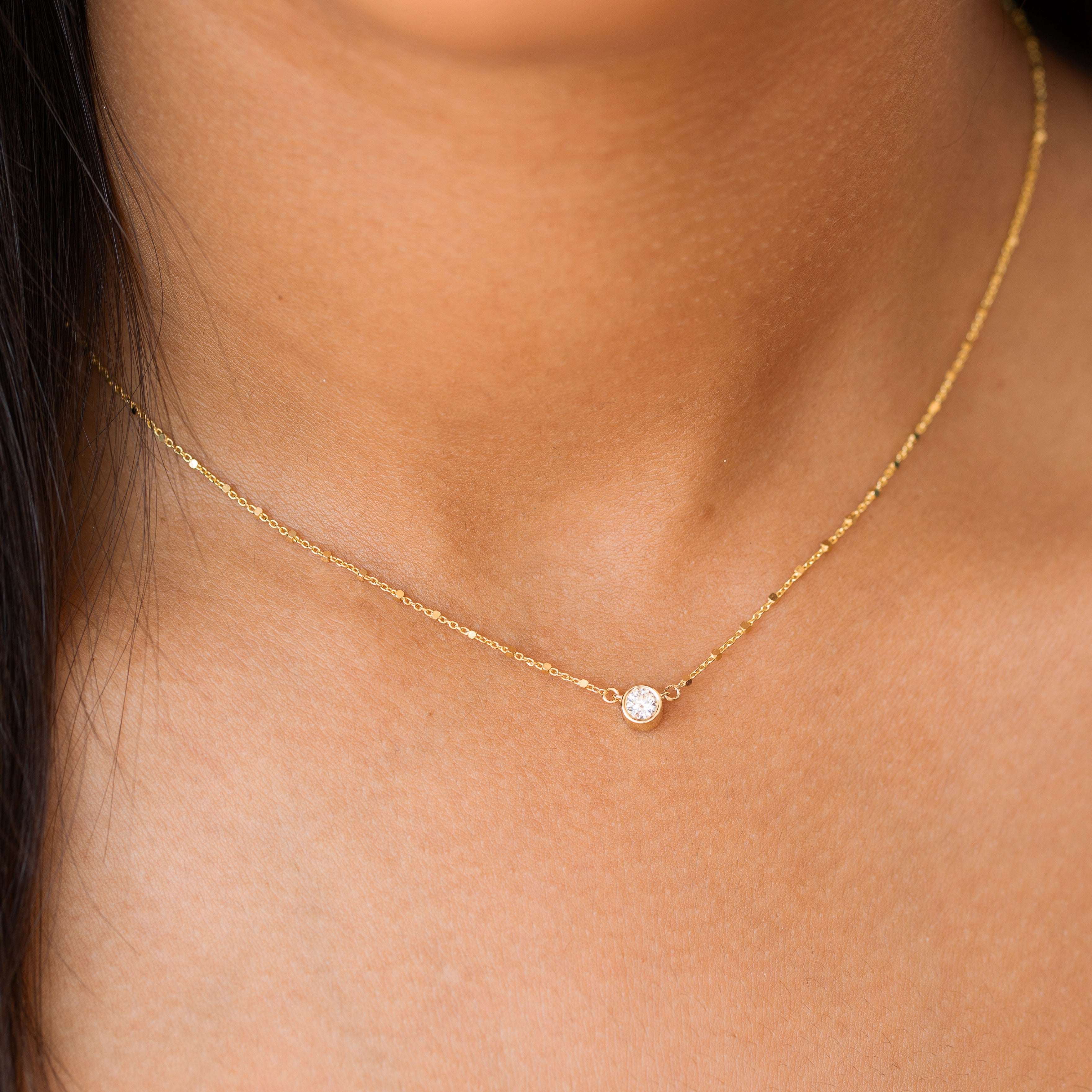 שרשרת יהלום מרחף עדינה על צוואר של אישה