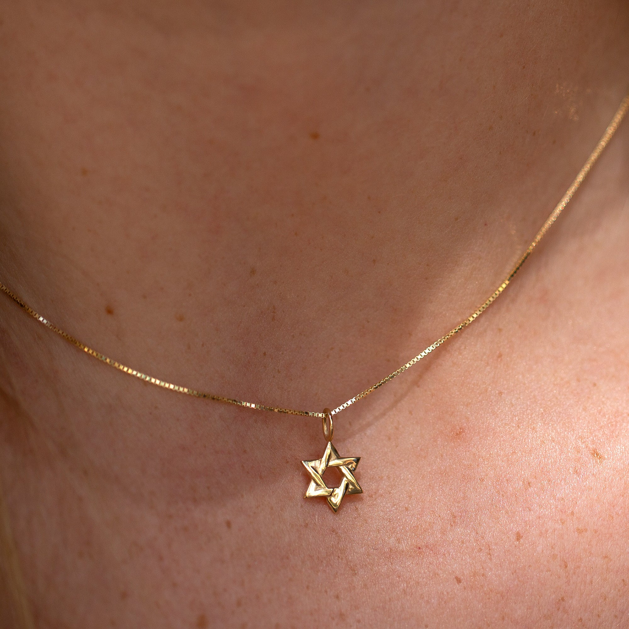 צילום תקריב של תליון מגן דוד על צוואר של דוגמנית