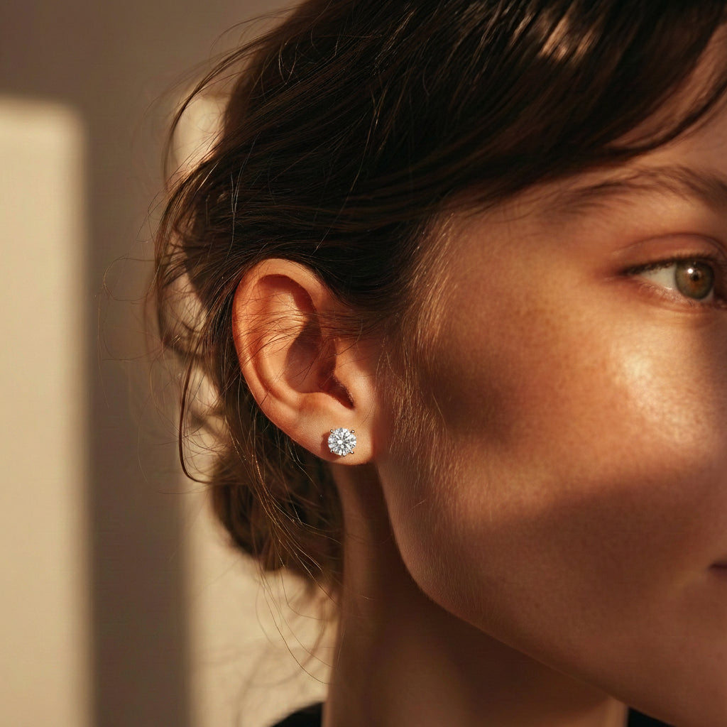 תקריב של פנים של אישה שעונדת עגילי יהלומים צמודים לאוזן במשקל 2 קראט