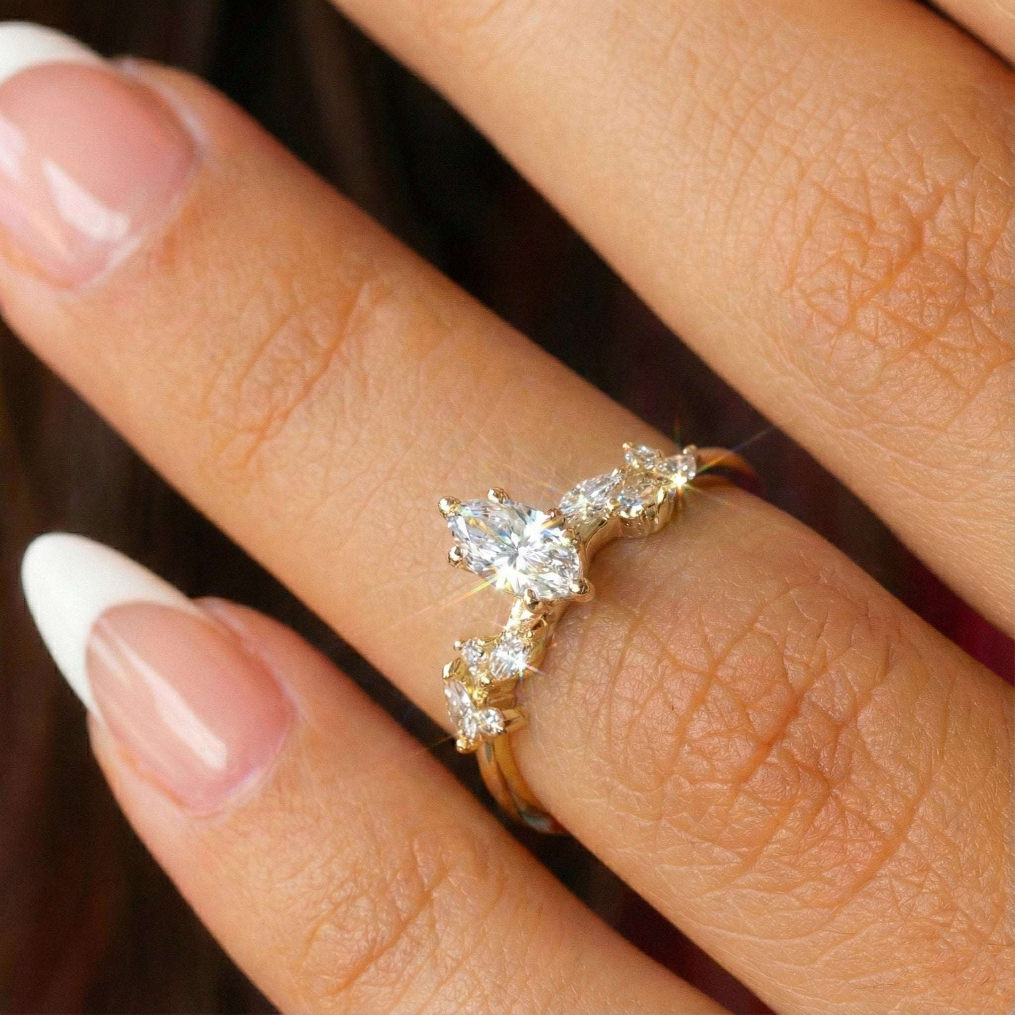 צילום תקריב של טבעת מרקיזה בזהב צהוב המציג את הפרטים העיצובים על היד.