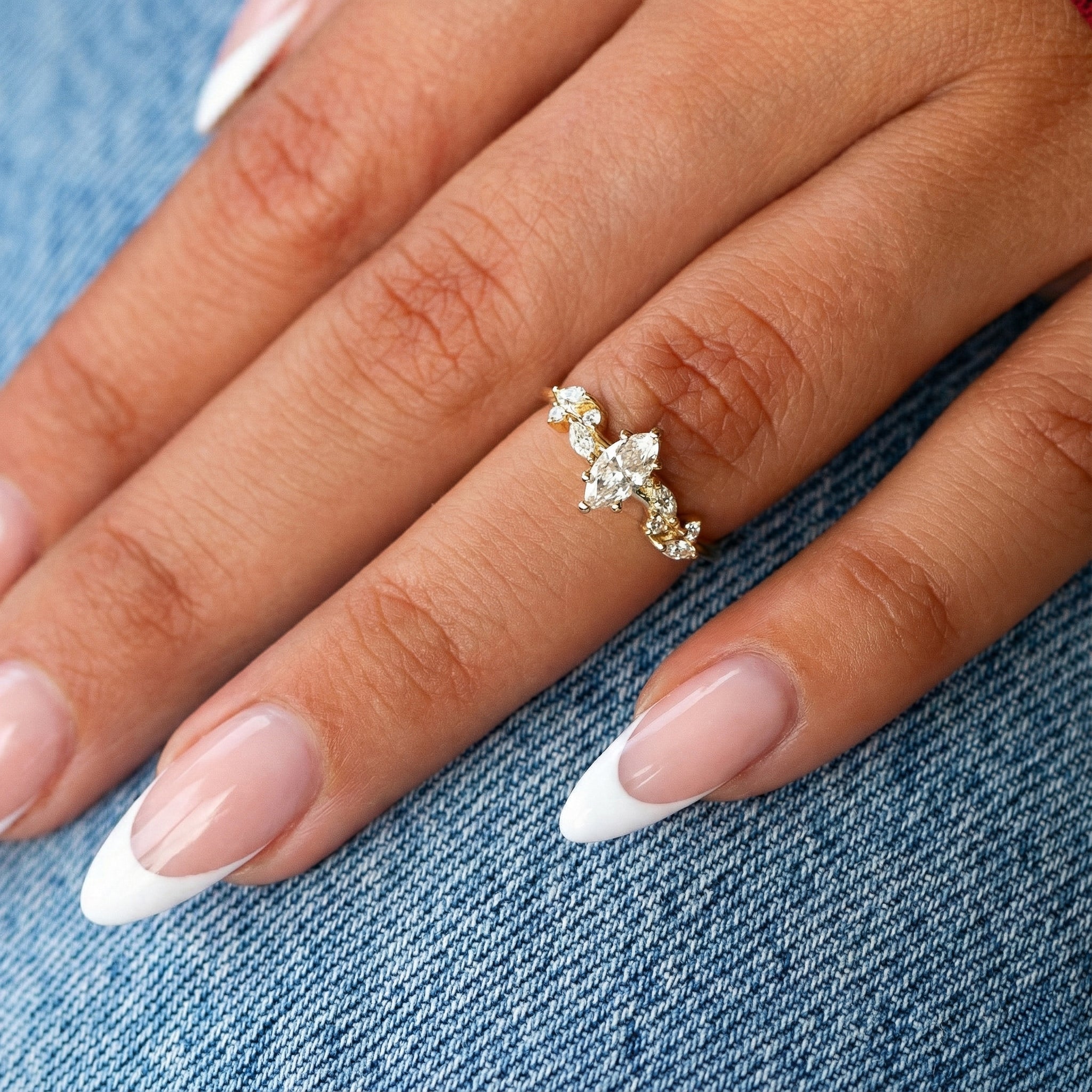 יד של דוגמנית עונדת טבעת מרקיזה פרחונית המדגימה את גודל היהלום על האצבע.