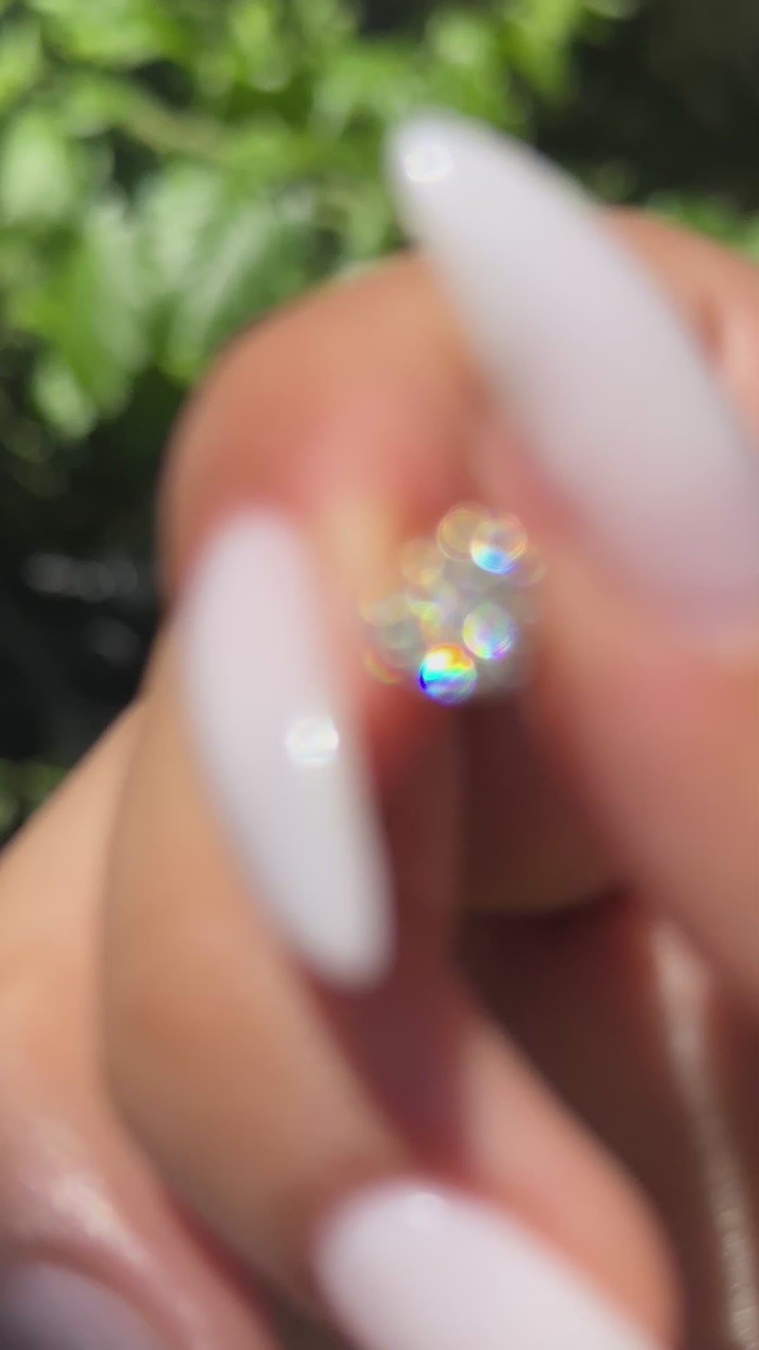 יד של אישה שמחזיקה עגיל לבבות מזהב צהוב משובץ יהלומים