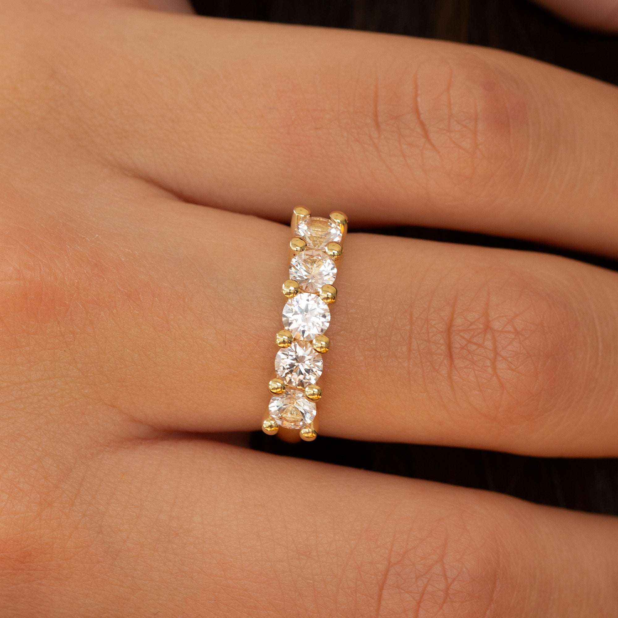 תקריב של טבעת זהב אדום משובצת שורת אבני מורגנייט