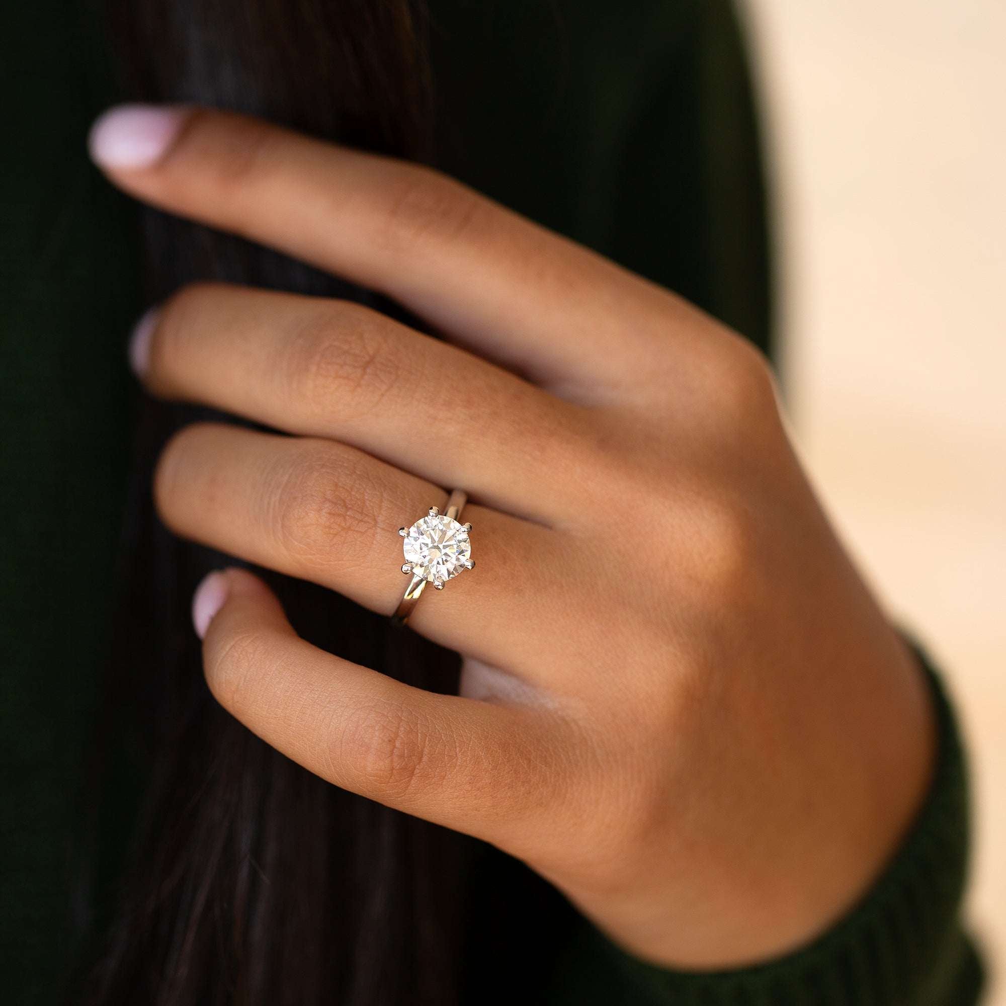 אישה עונדת טבעת אירוסין 2 קראט בזהב לבן משובצת יהלום גדול