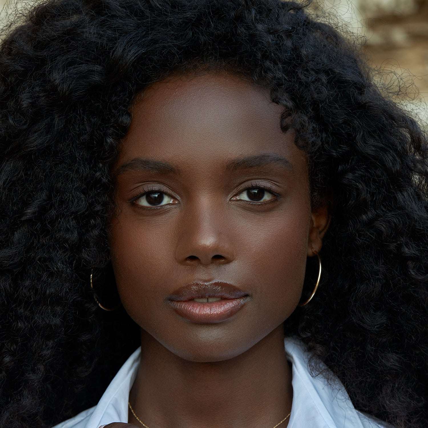 אישה עונדת עגילי חישוק זהב גדולים ועדינים