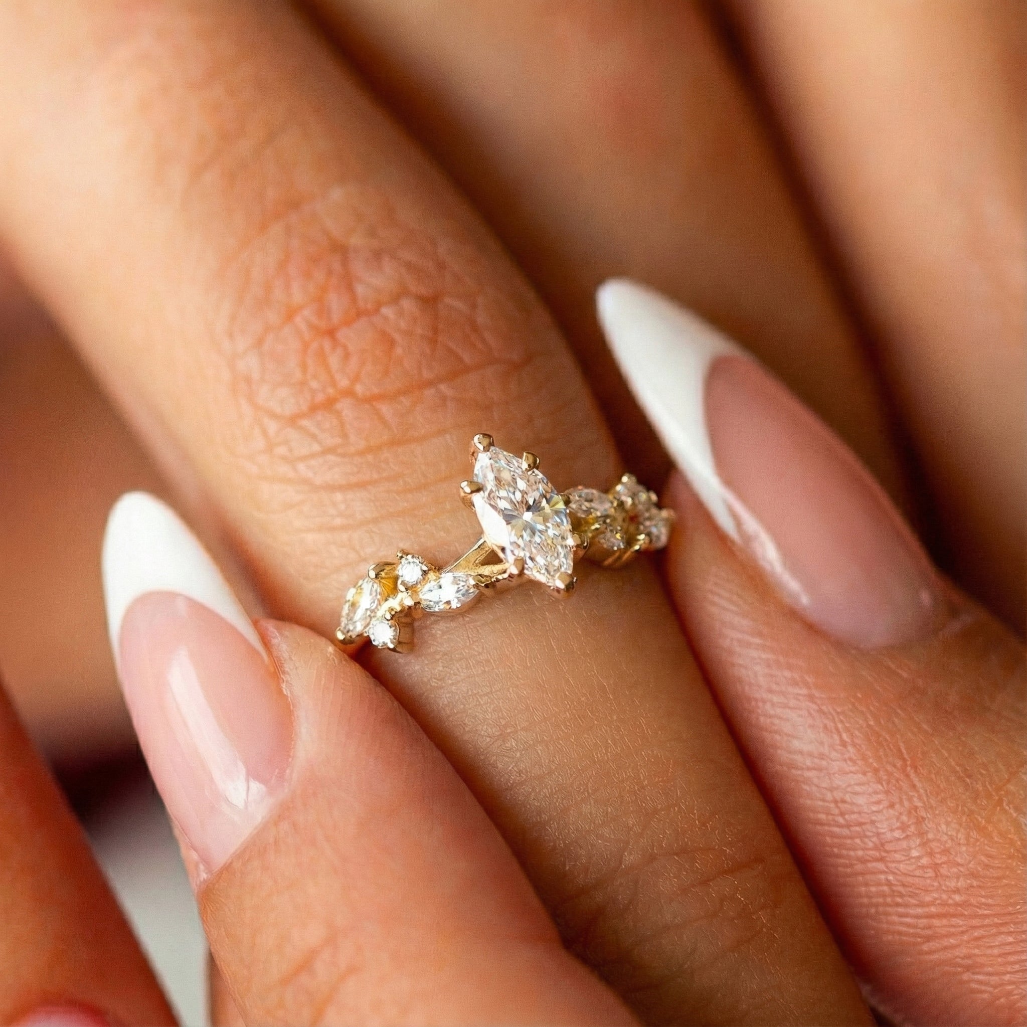 תקריב של טבעת אירוסין עדינה על אצבע דוגמנית המדגישה את המראה המוארך