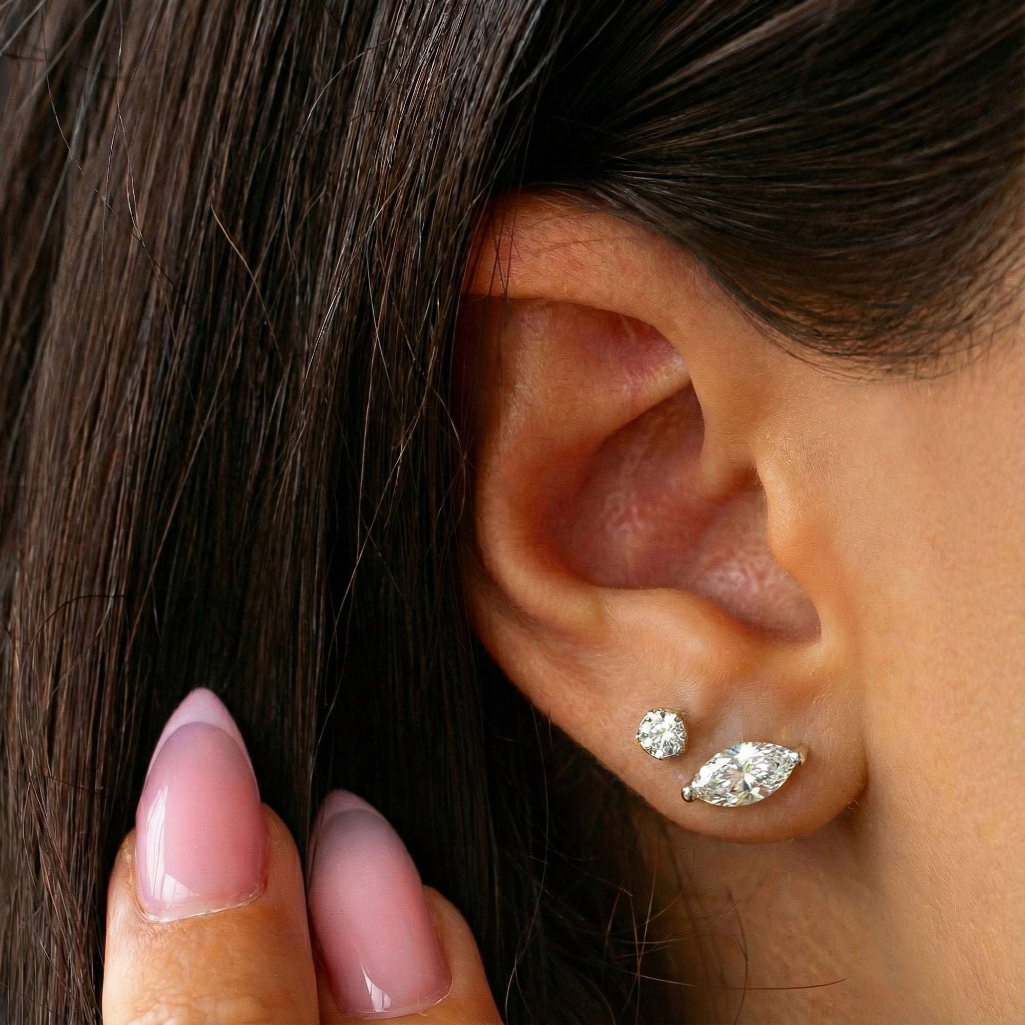 אוזן של אישה שעונדת עגילי יהלום סוליטר מרקיזה במשקל 1 קראט